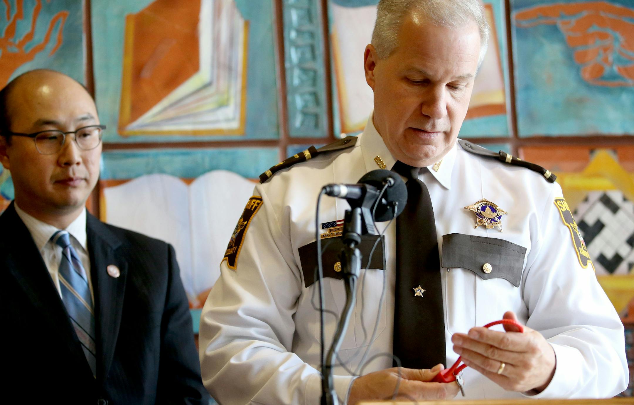 Ramsey County Sheriff Matt Bostrom looks at a gun lock while joining forces with Ramsey County Attorney John Choi to announce that Ramsey County will make available 2,500 free gun locks to encourcage gun owners to lock, secure guns to keep children and the community safe at a press conference Thursday, June 9, 2016, at the Rondo Community Outreach Library in St. Paul, MN.](DAVID JOLES/STARTRIBUNE)djoles@startribune In an urthodox effort to combat gunplay by children, the Ramsey County attorney&#