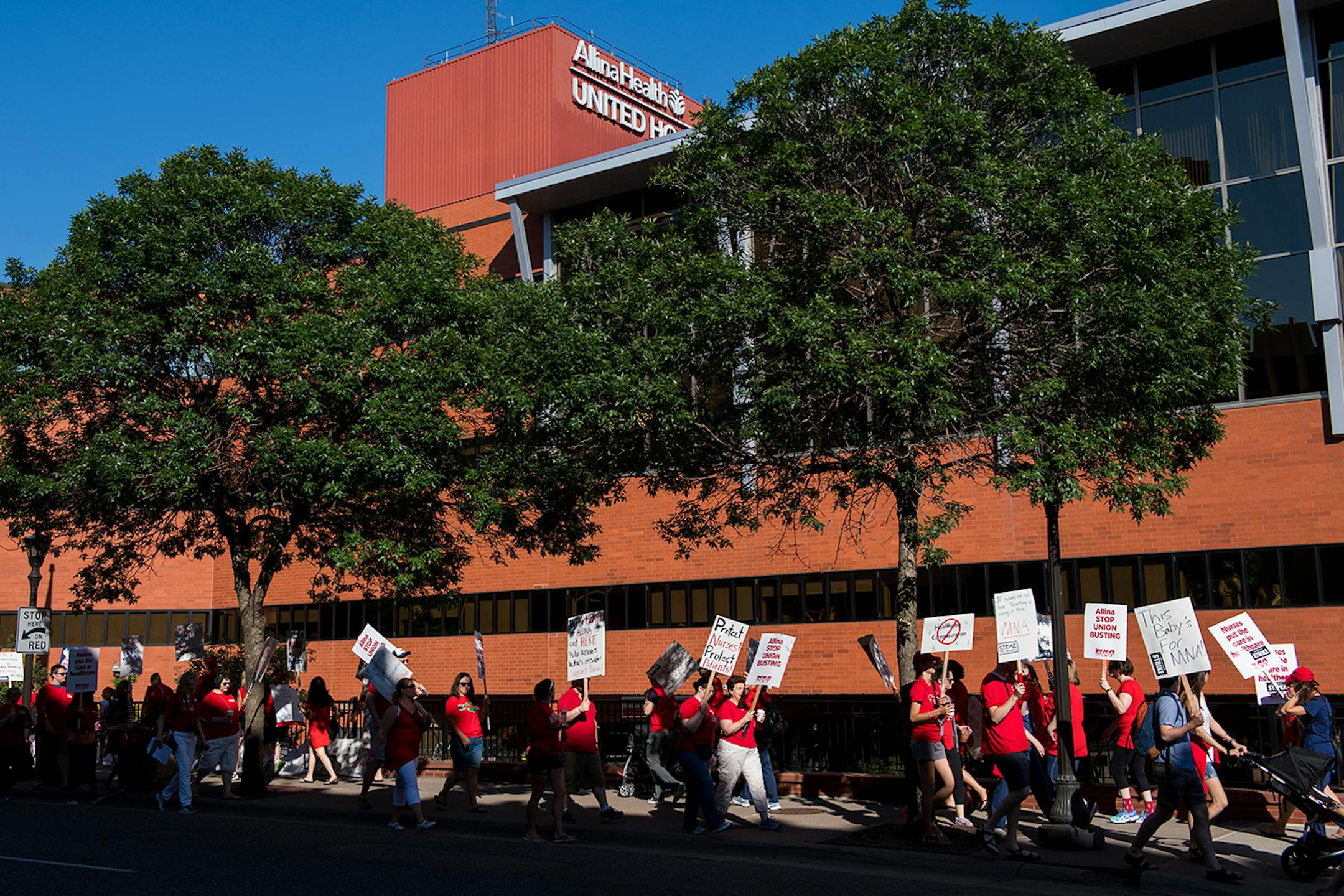 Picketers walk in front of United Hospital in St. Paul. Pickets will continue from 7 a.m. to 7 p.m. today.