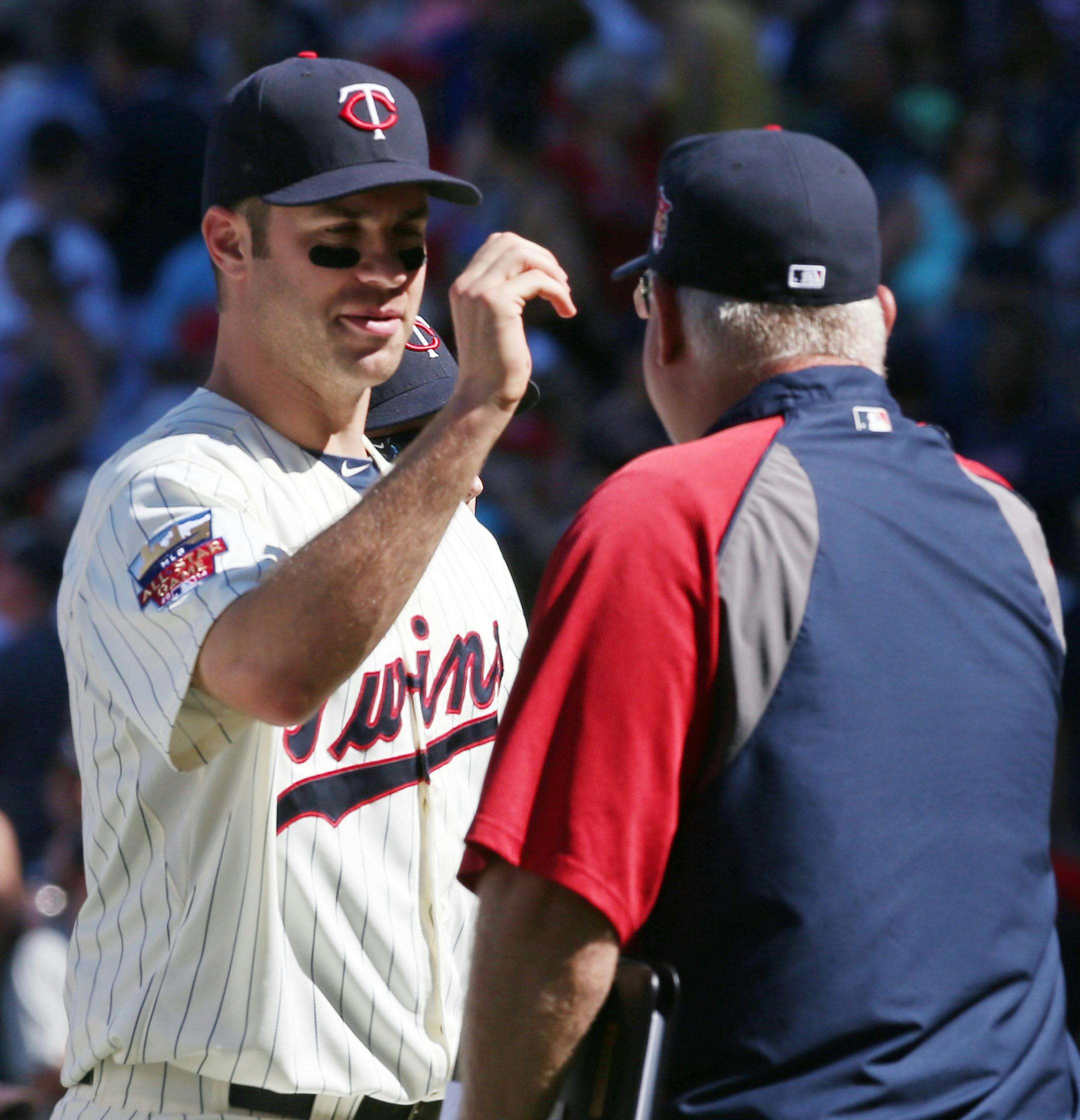 Minnesota Twins manager Ron Gardenhire, right, celebrates with Joe Mauer after their 4-3 win over the Chicago White Sox in a baseball game, Saturday, June 21, 2014, in Minneapolis. Mauer had two RBI's. (AP Photo/Jim Mone)
