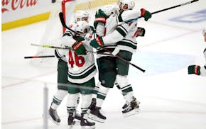 Minnesota Wild defenseman Mathew Dumba, right, leaps into the arms of left wing Kirill Kaprizov, second from right, after an overtime goal against the