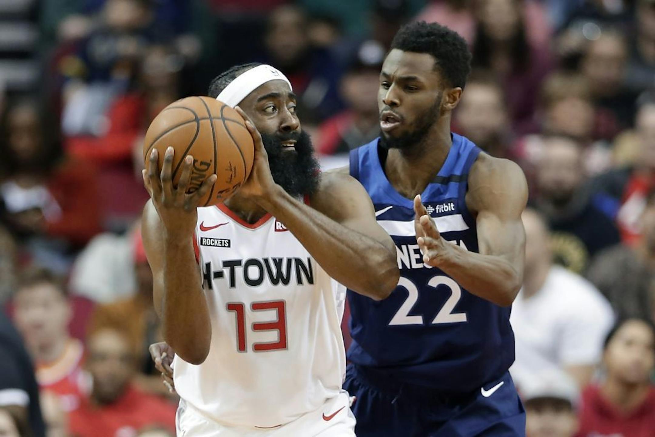 Houston Rockets guard James Harden (13) looks to pass the ball under pressure from Minnesota Timberwolves forward Andrew Wiggins (22) during the first half of an NBA basketball game Saturday, Jan. 11, 2020, in Houston.