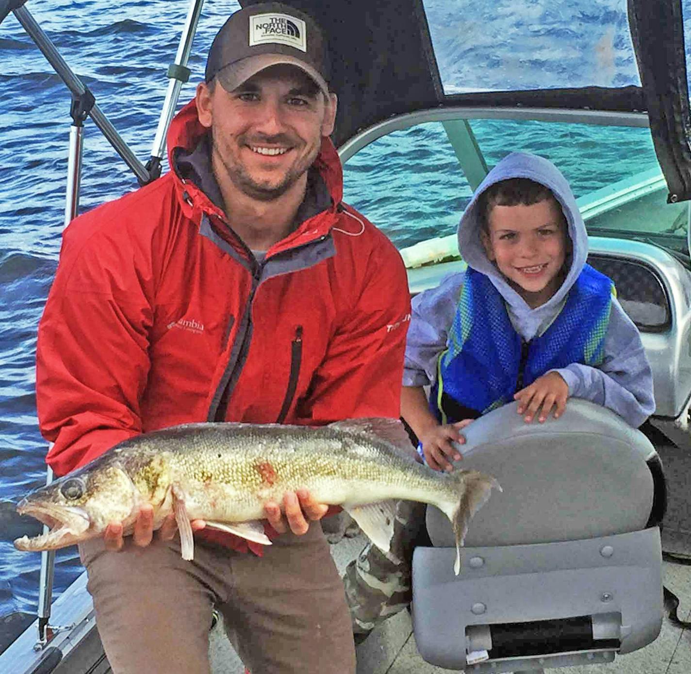 Mike Ward shows off a 28-inch walleye caught in Miles Bay, Lake of the Woods, as Jack Kennedy, 7, looks on.