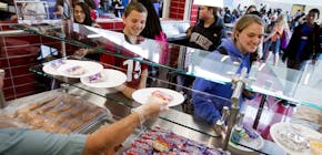 In a May 19, 2017 photo, Mount Jordan Middle School students get lunch in their school's cafeteria in Sandy, Utah. Canyons School District administrat