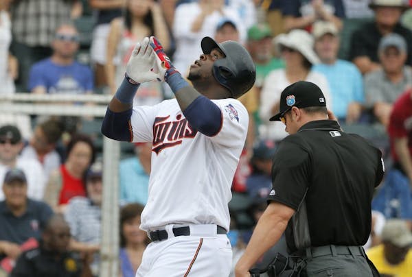 Minnesota Twins' Miguel Sano celebrates after crossing home plate on his solo home run off of Boston Red Sox's Joe Kelly in the first inning as umpire