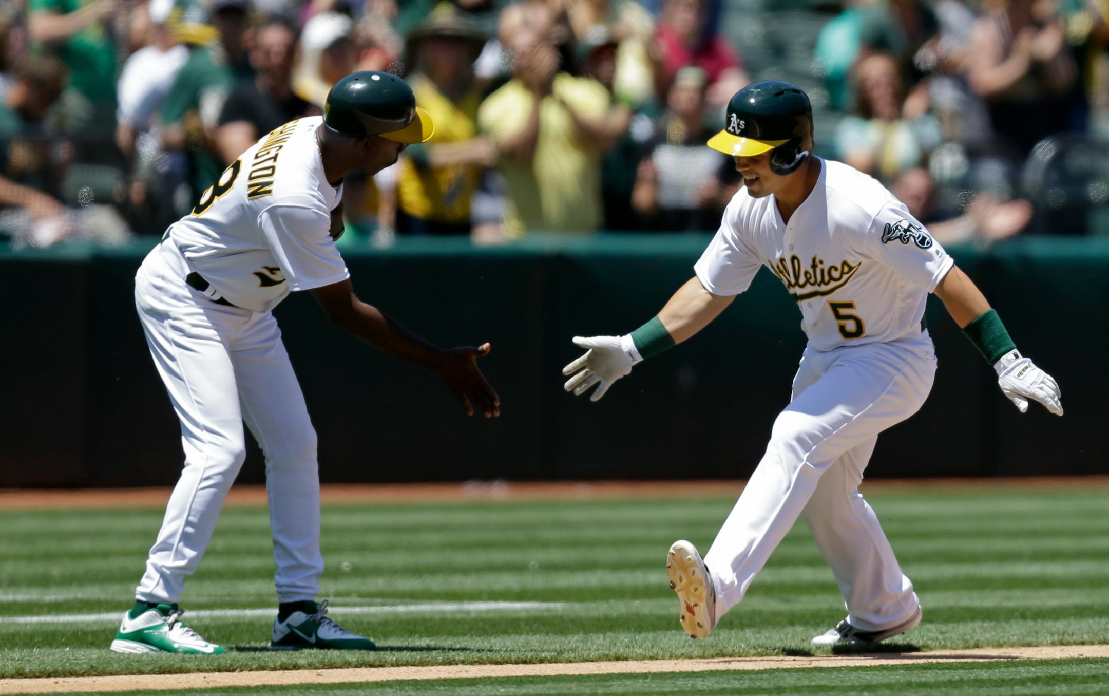 Oakland Athletics' Jake Smolinski, right, is congratulated by third base coach Ron Washington after hitting a home run off Minnesota Twins pitcher Pat Dean in the fourth inning of a baseball game Wednesday, June 1, 2016, in Oakland, Calif. (AP Photo/Ben Margot)