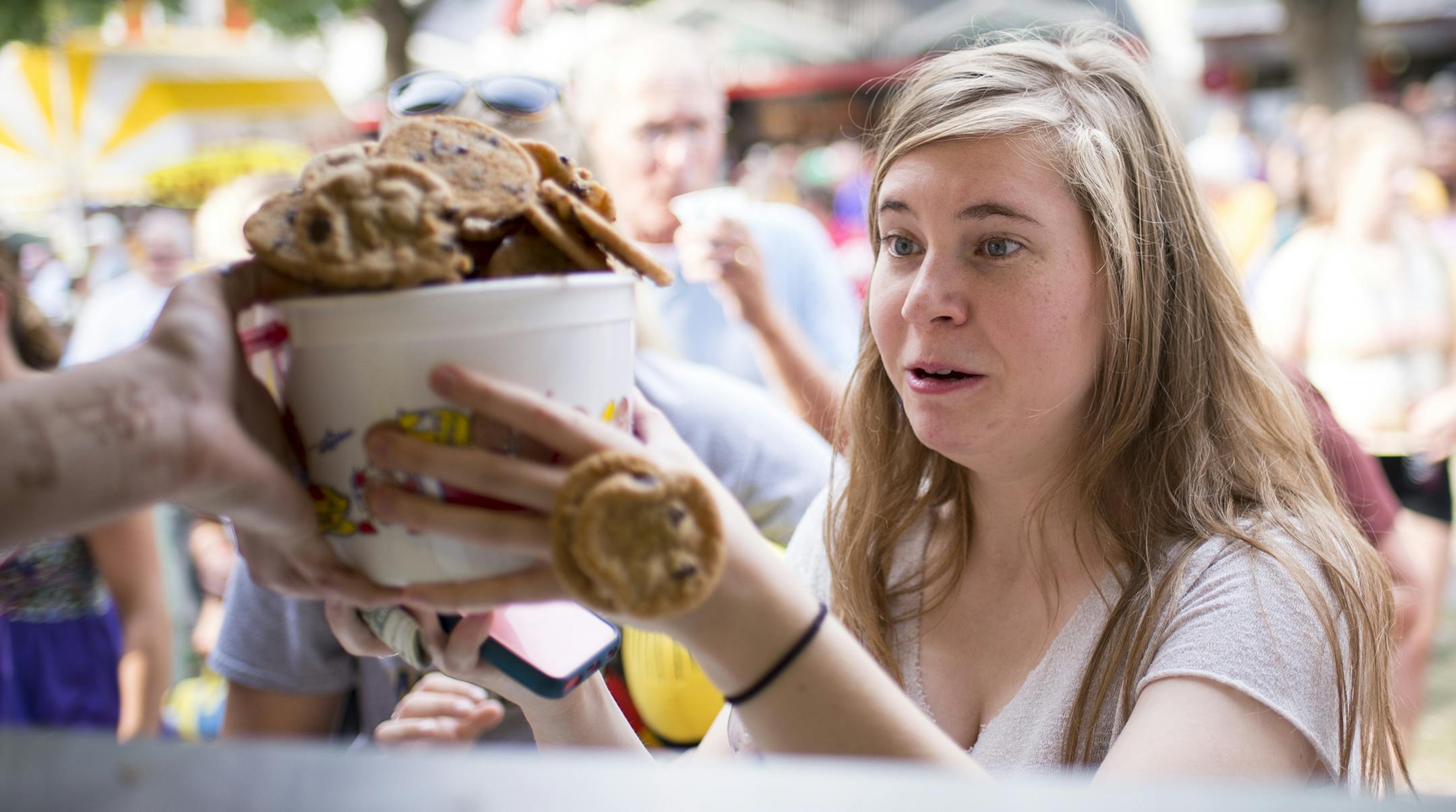 Catherine Guden, of Apple Valley, watched as cookies fell out of her bucket as they were being handed to her at Sweet Martha's Cookie Jar Thursday. ] Aaron Lavinsky • aaron.lavinsky@startribune.com Behind the scenes at one of the State Fair's most quintessential booths: Sweet Martha's Cookie Jar. Started in 1979 by Martha Olson, the booth has moved and expanded six times, but still can't keep up with the massive lines. Martha estimates they bake and sell 1 million cookies a day during the