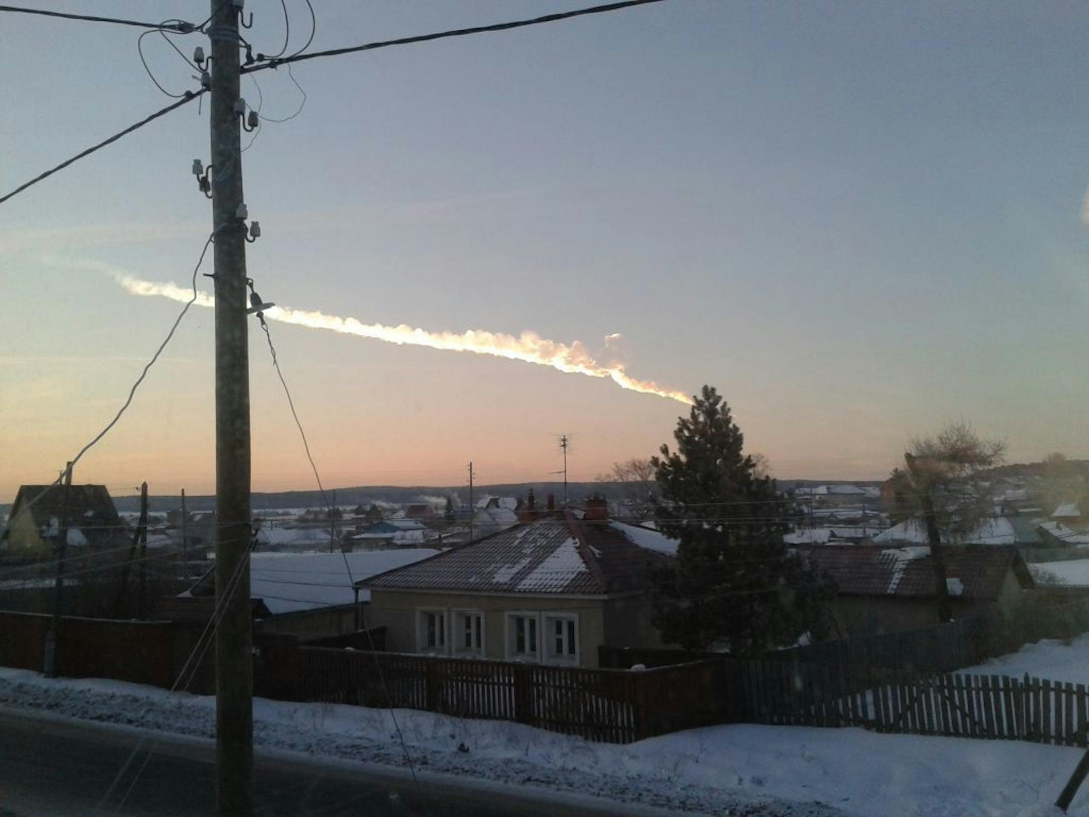 In this photo provided by E1.ru a meteorite contrail is seen over a vilage of Bolshoe Sidelnikovo 50 km of Chelyabinsk on Friday, Feb. 15, 2013. A meteor streaked across the sky of Russia�s Ural Mountains on Friday morning, causing sharp explosions and reportedly injuring around 100 people, including many hurt by broken glass.