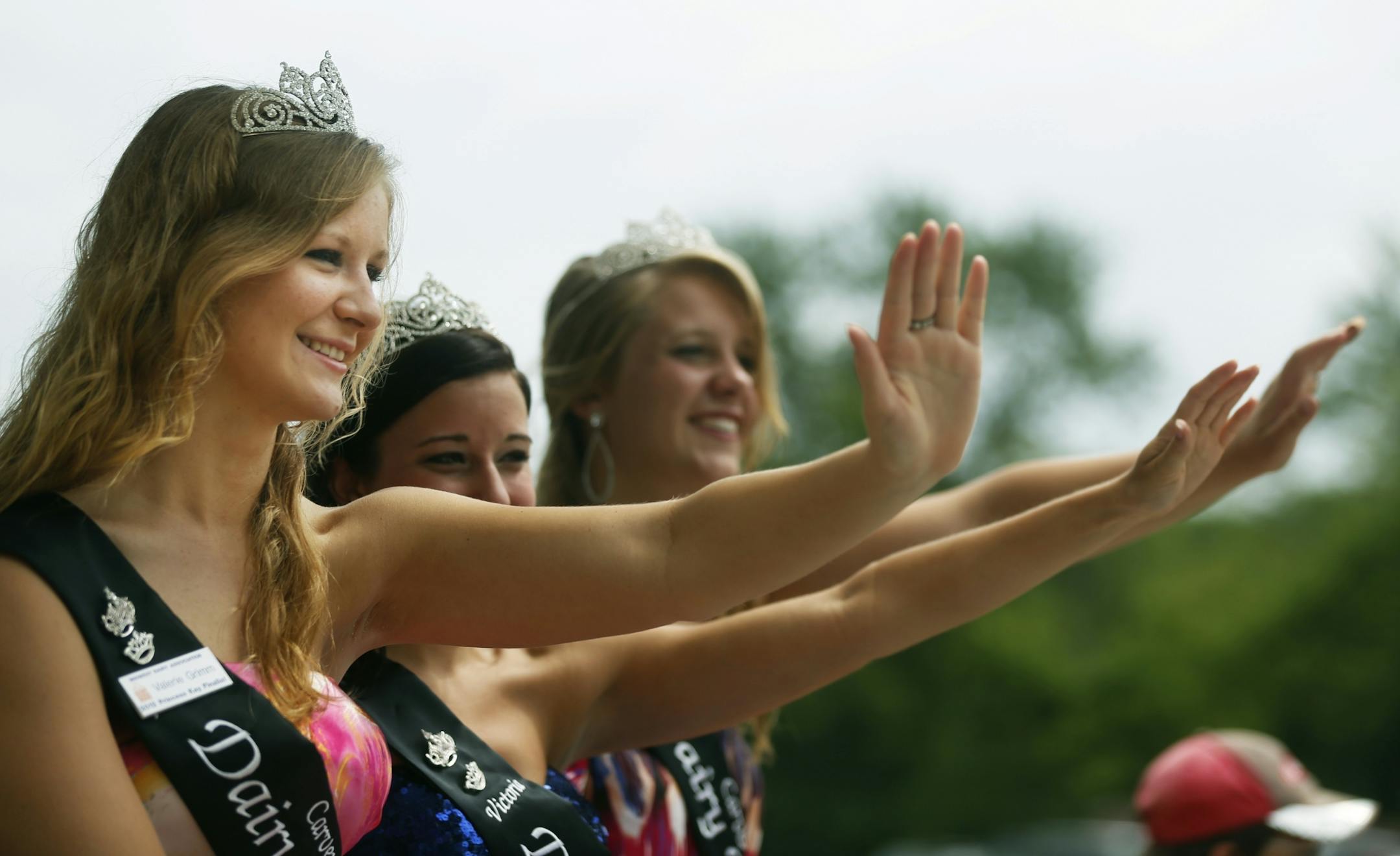 At a parade in Watertown, Princess Kay contestants and Carver County Princesses Val Grimm, Victoria Haler, and Christine Leonard waved to parade goers. Val Grimm maintains a busy schedule of appearances during the summer.