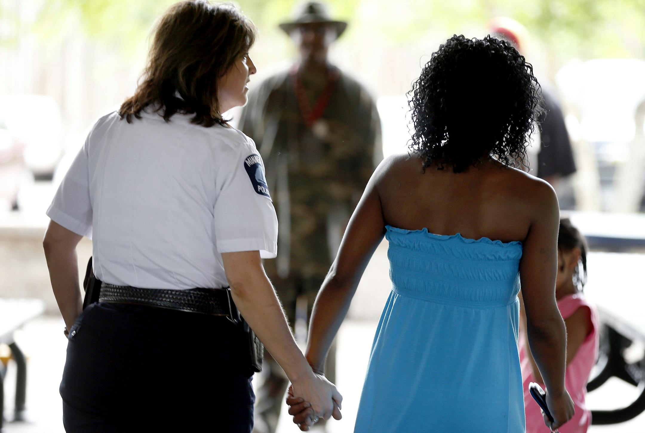 Minneapolis police chief Janee Harteau, held hands with Rochelle Banks-Wowo during a joint celebration and remembrance at North Mississippi Regional Park in Minneapolis on Wednesday. Banks-Wowo is the grandmother of Nizzel George. The day marked the one-year anniversary of the shooting death of 5-year-old Nizzel George. Friends and family were also celebrating the 70th birthday of his great grandmother Nancy Lee Banks and a baby shower for Nizzel's mother Christina Banks who is expecting a child