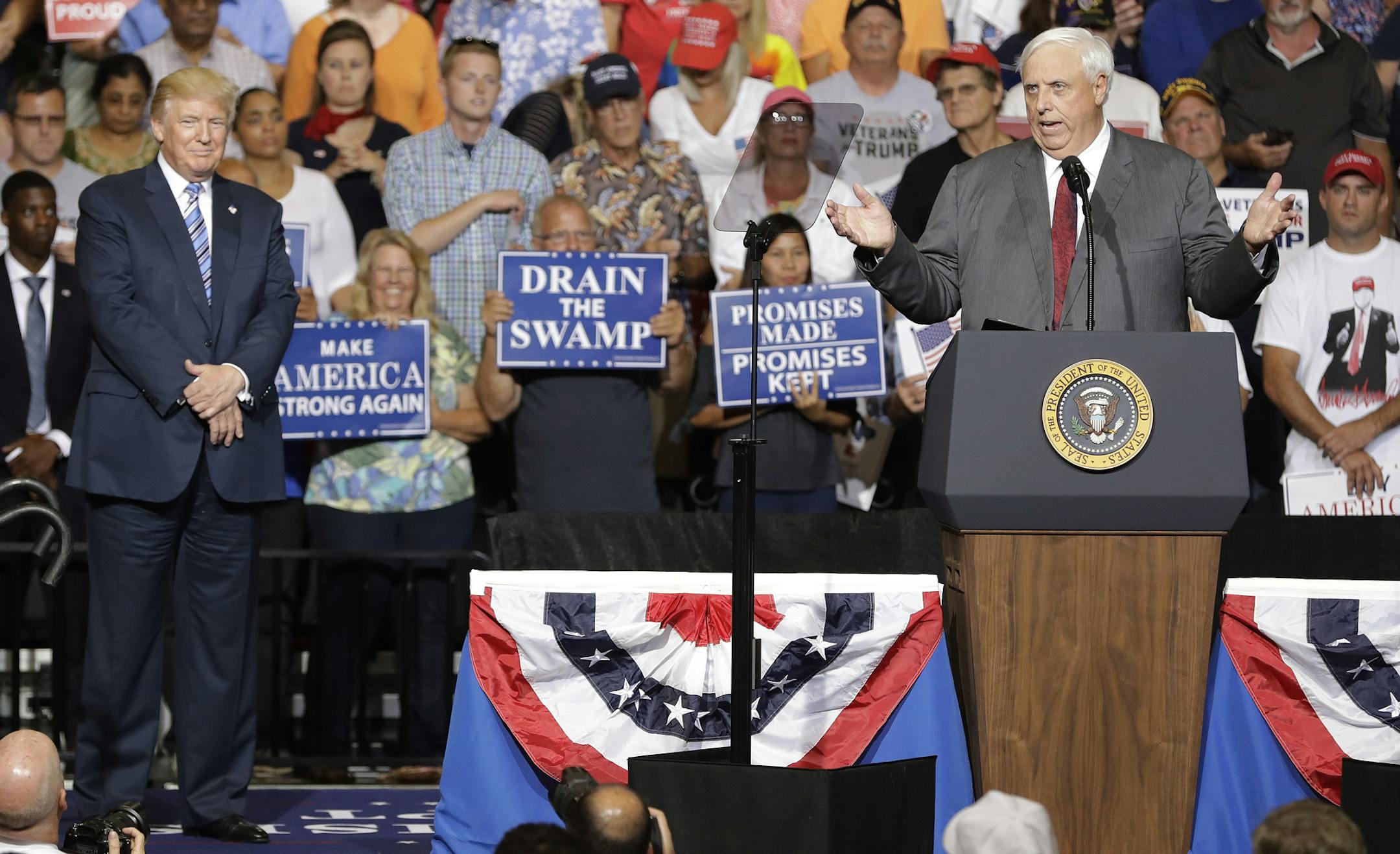 President Donald Trump listens as West Virginia Gov. Jim Justice speaks during a rally Thursday, Aug. 3, 2017, in Huntington, W.Va. Justice, a Democrat, announced that he is switching parties to join the Republicans.(AP Photo/Darron Cummings)