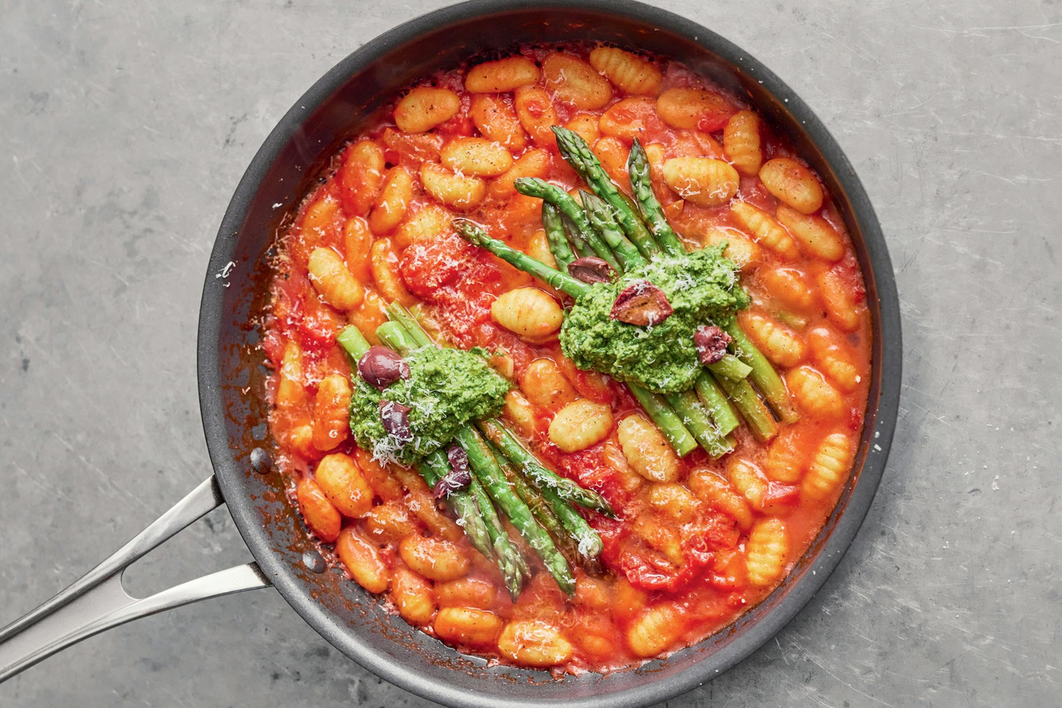 SWEET TOMATO GNOCCHI with Fresh Spinach &amp; Hazelnut Pesto, Asparagus &amp; Olives from "Simple One-Pan Wonders" by Jamie Oliver (Flatiron, 2023). Photos: Davis Loftus and Richard Clatworthy