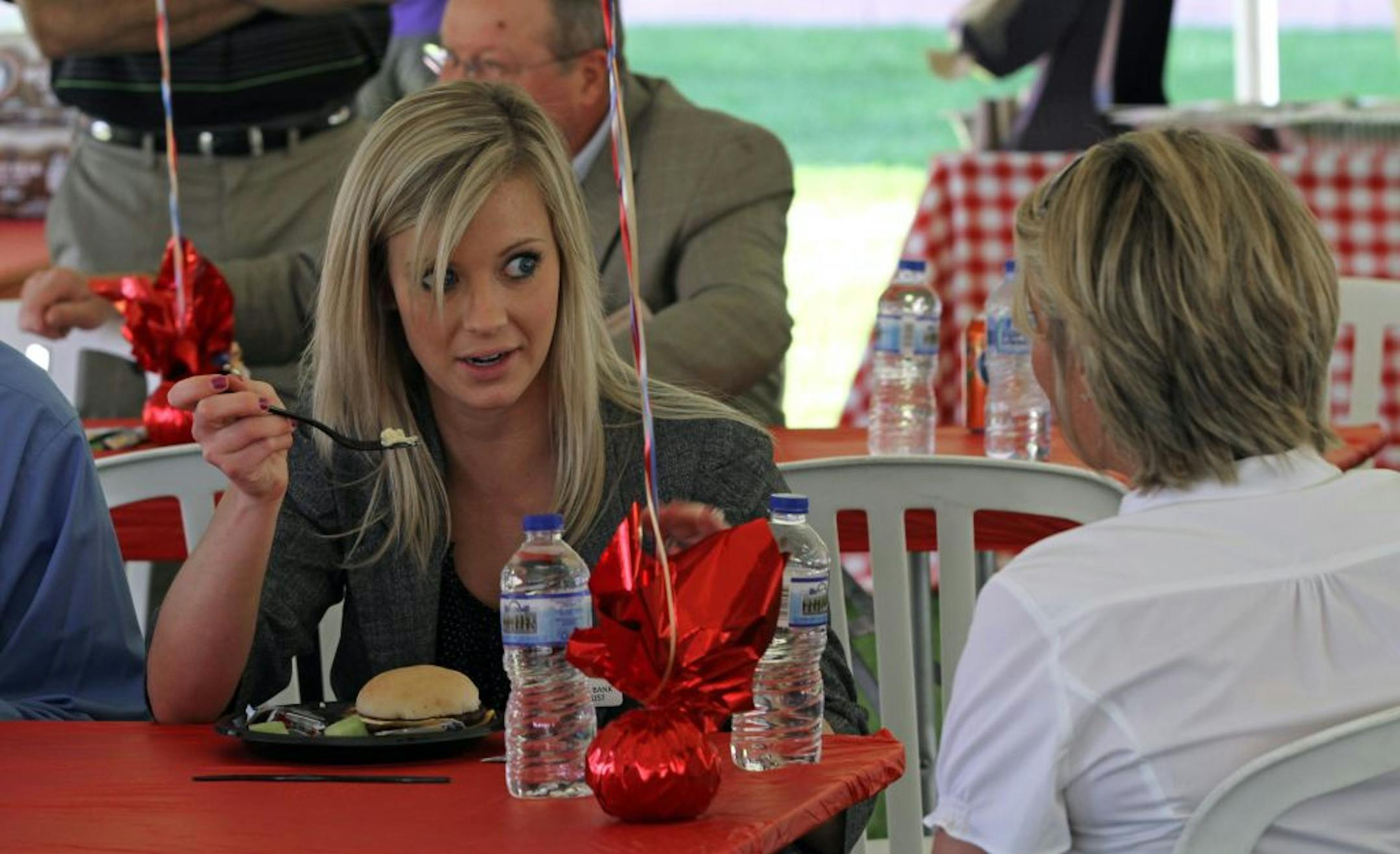 (left to right) State Bank & Trust Personal Banker Anna Abeld talked with fellow employee Kris Williams during the employee appreciation day lunch cookout at the bank building in Golden Valley on 5/15/12.