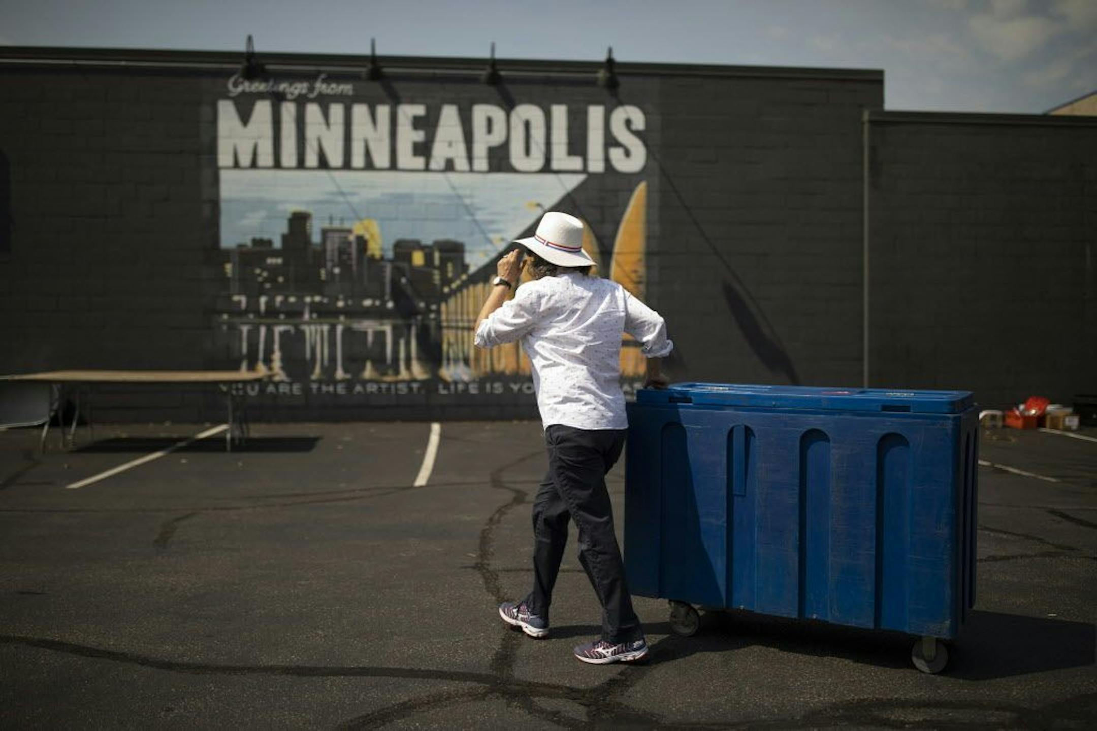 Kim Bartmann hauls a cooler full of ice while getting ready for Red Stag's 12th annual block party in August.