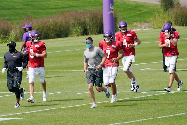 Vikings quarterbacks Jake Browning (3), Nate Stanley (7), Sean Mannion (4) and Kirk Cousins (8) headed to their practice area during training camp Mon
