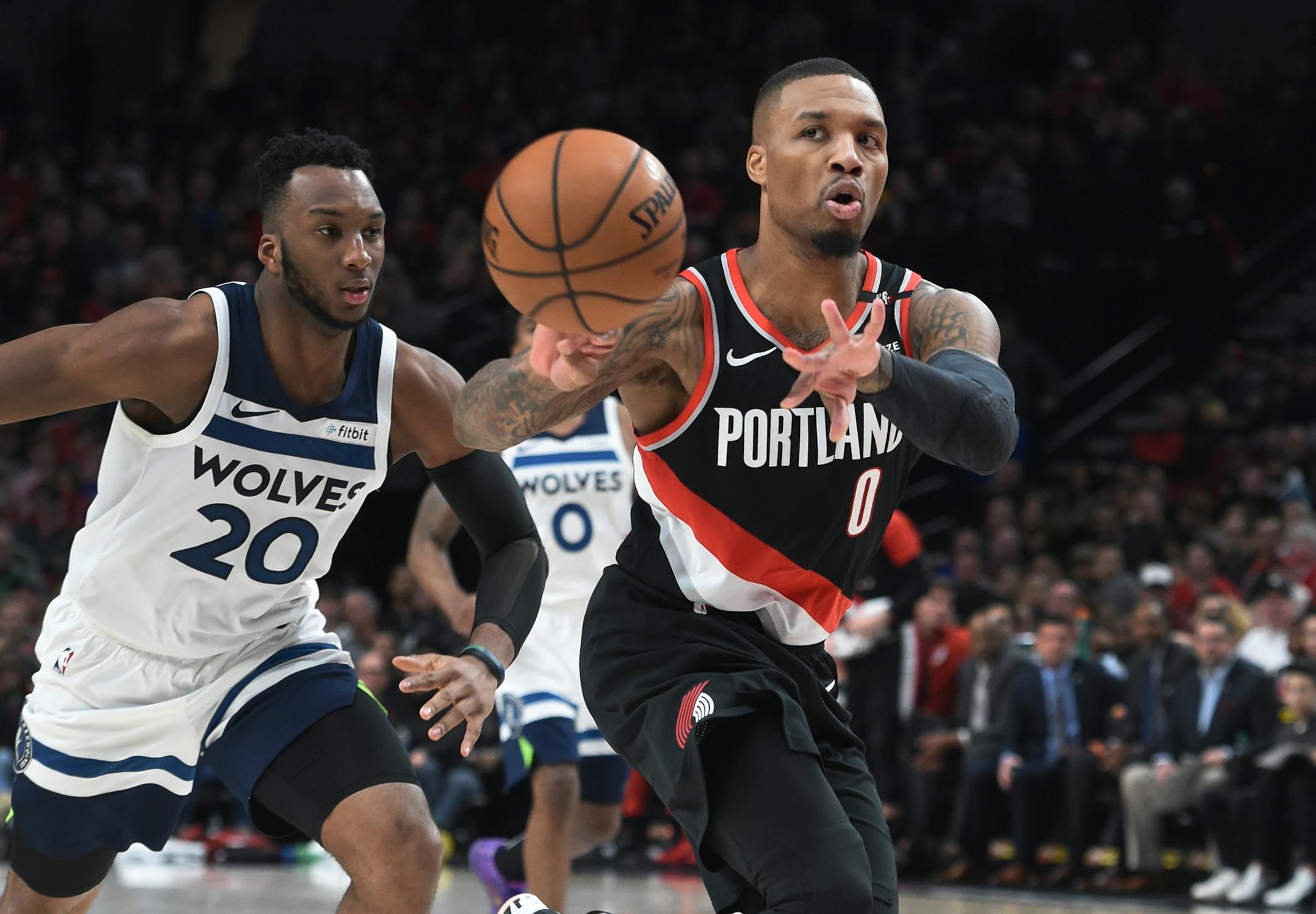 Portland Trail Blazers guard Damian Lillard, right, passes the ball away from Minnesota Timberwolves guard Josh Okogie during the second half of an NBA basketball game in Portland, Ore., Saturday, Dec. 8, 2018. The Blazers won 113-105. (AP Photo/Steve Dykes)