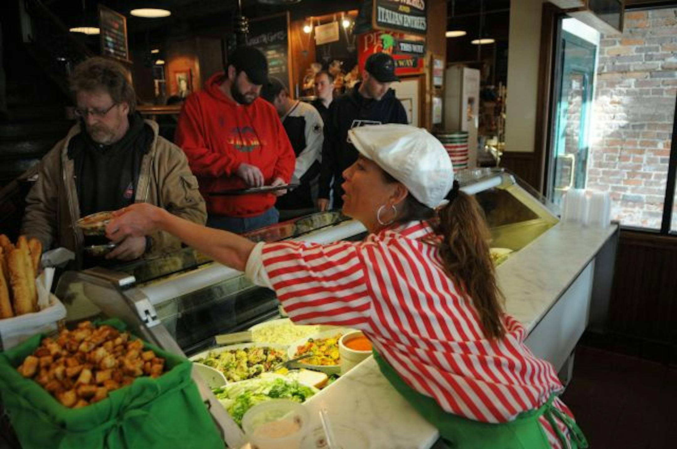 Cosetta's, St. Paul's 100-year-old landmark pizzeria and market, is planning a massive expansion to double the size of the seating area, triple the size of the market and add a seasonal rooftop restaurant. Megan Chesley serves cold salads to the lunch time crowd.