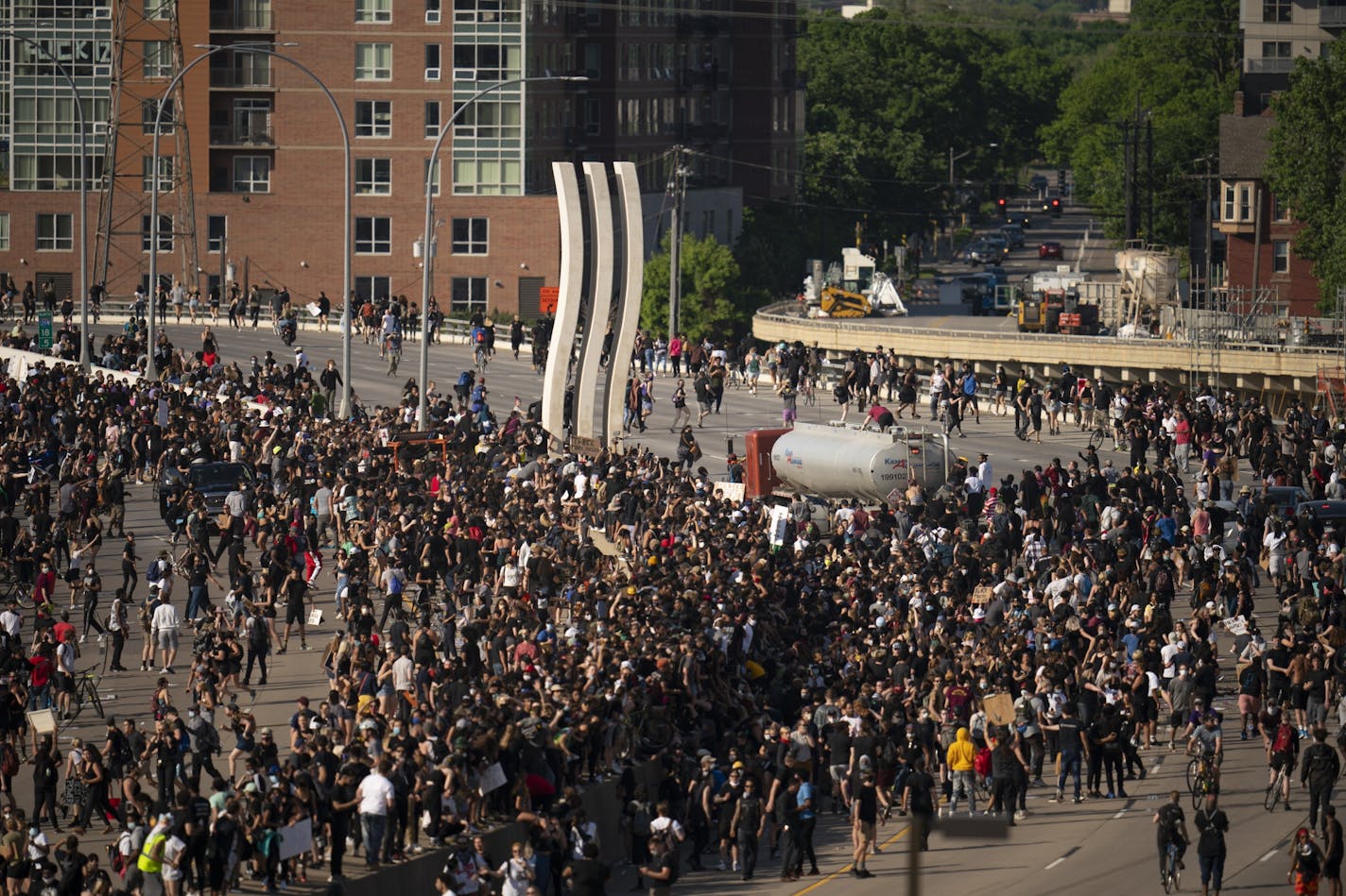 People climbed atop a tanker as it continued to move after plowing into protesters who had marched onto the Interstate 35W bridge in Minneapolis on Sunday.