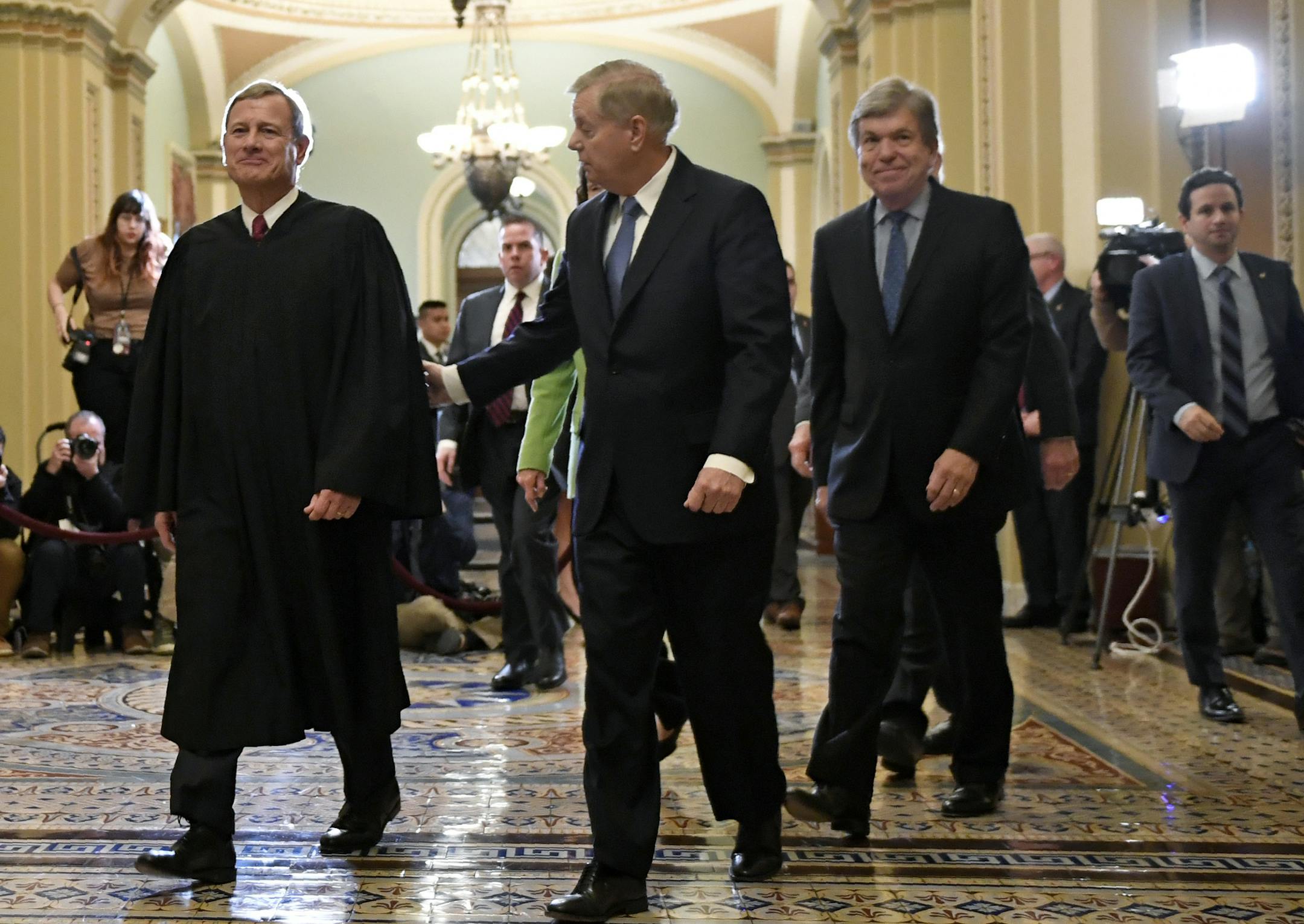 Sen. Lindsey Graham, R-S.C., center, talks with Supreme Court Chief Justice John Roberts, left, as they walk out of the Senate Chamber on Capitol Hill in Washington, Wednesday, Feb. 5, 2020, following a vote to acquit President Donald Trump on both articles of impeachment. Rep. Roy Blunt, R-Mo., follow behind. (AP Photo/Susan Walsh)