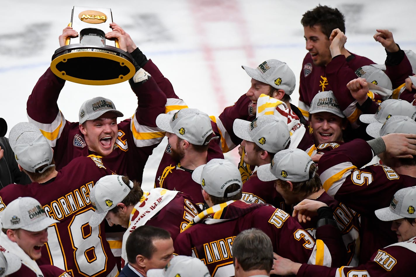 Minnesota Duluth forward Karson Kuhlman hoisted the NCAA championship trophy over his head while celebrating with teammates following a 2-1 victory over Notre Dame