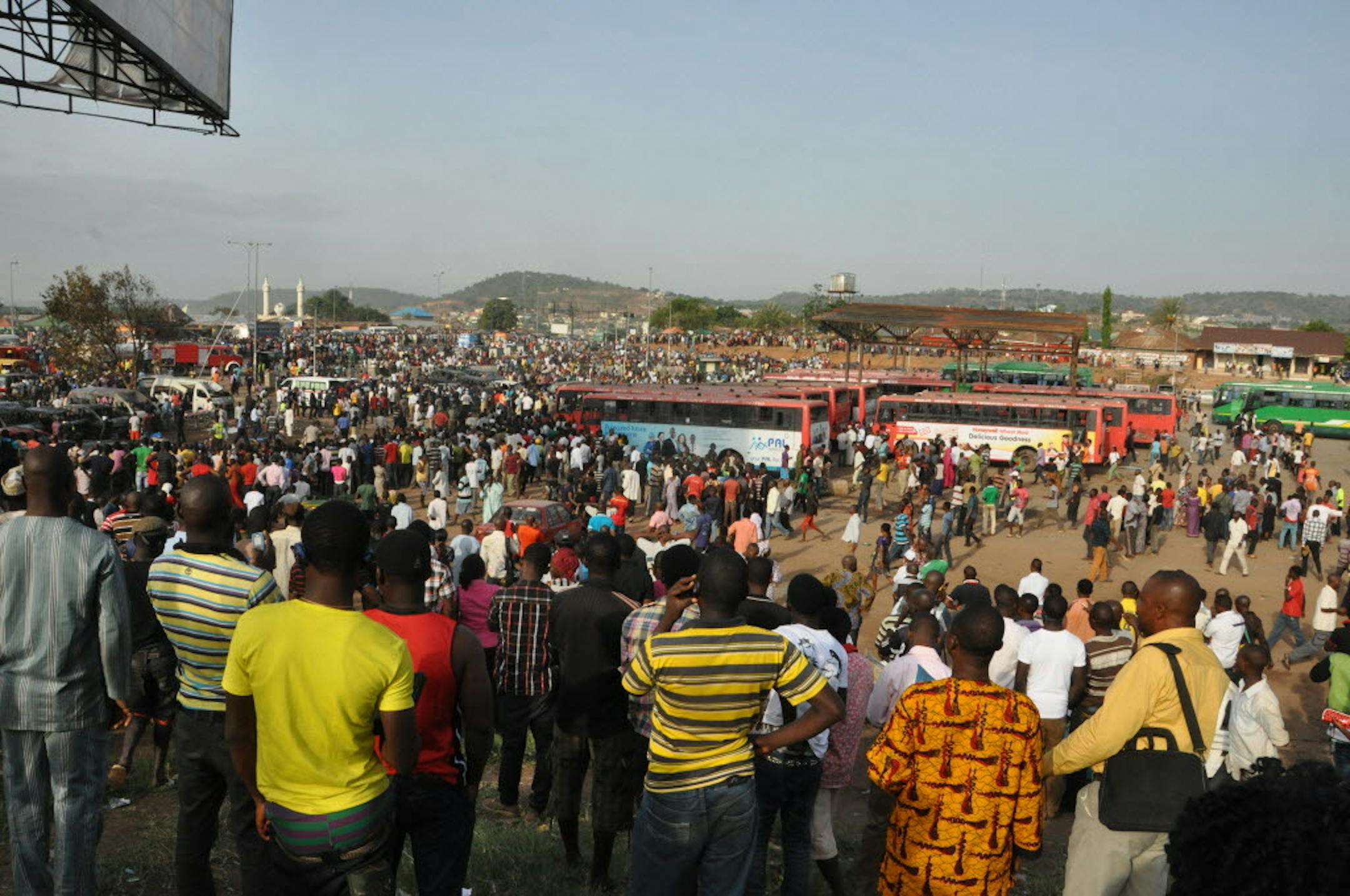 People gather near the site of a blast at the Nyanya Motor Park, about 16 kilometers (10 miles) from the center of Abuja, Nigeria