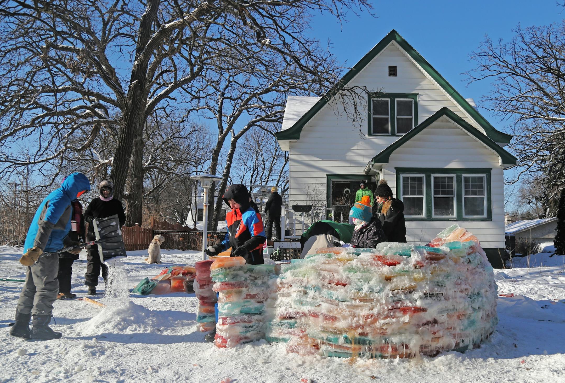 Martha Palm, her family and some former students of hers will be working on the multi-colored igloo they are building at the Palms' south Minneapolis home and seen Saturday, Dec. 30, 2017, in Minneapolis, MN. Here, a mixture of snow and water was mixed together to form the mortar to bond the ice blocks together. Members of the Palm and Zirps family as well as Martha's Palm's former students and neighbors built the igloo.