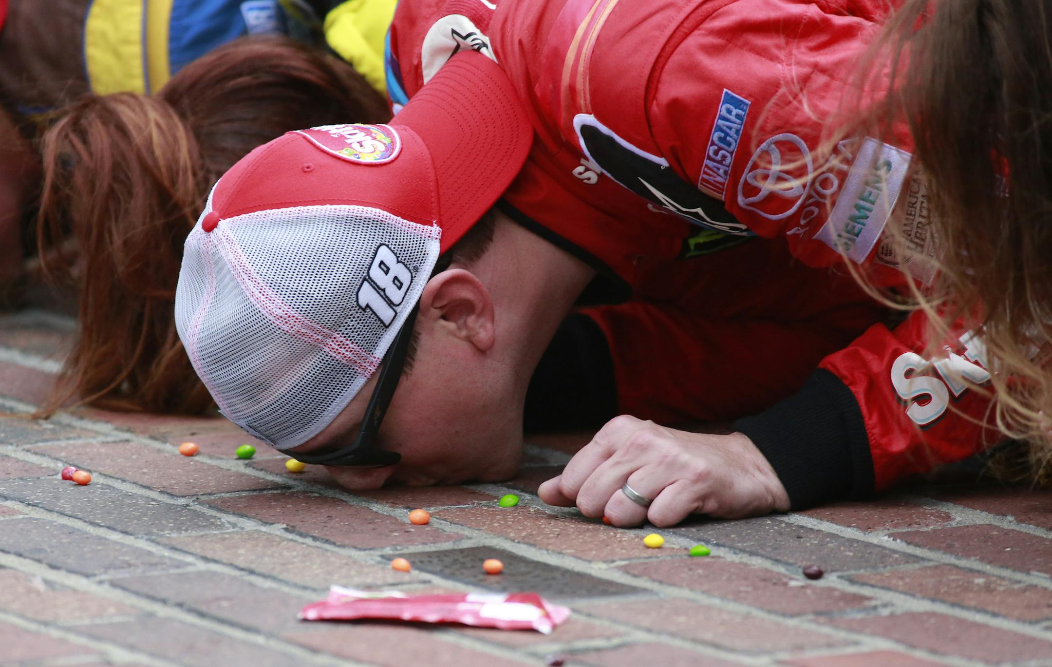 Sprint Cup Series driver Kyle Busch (18) kisses the bricks on the start/finish line after winning the NASCAR Brickyard 400 auto race at Indianapolis Motor Speedway in Indianapolis, Sunday, July 26, 2015. (AP Photo/R Brent Smith)