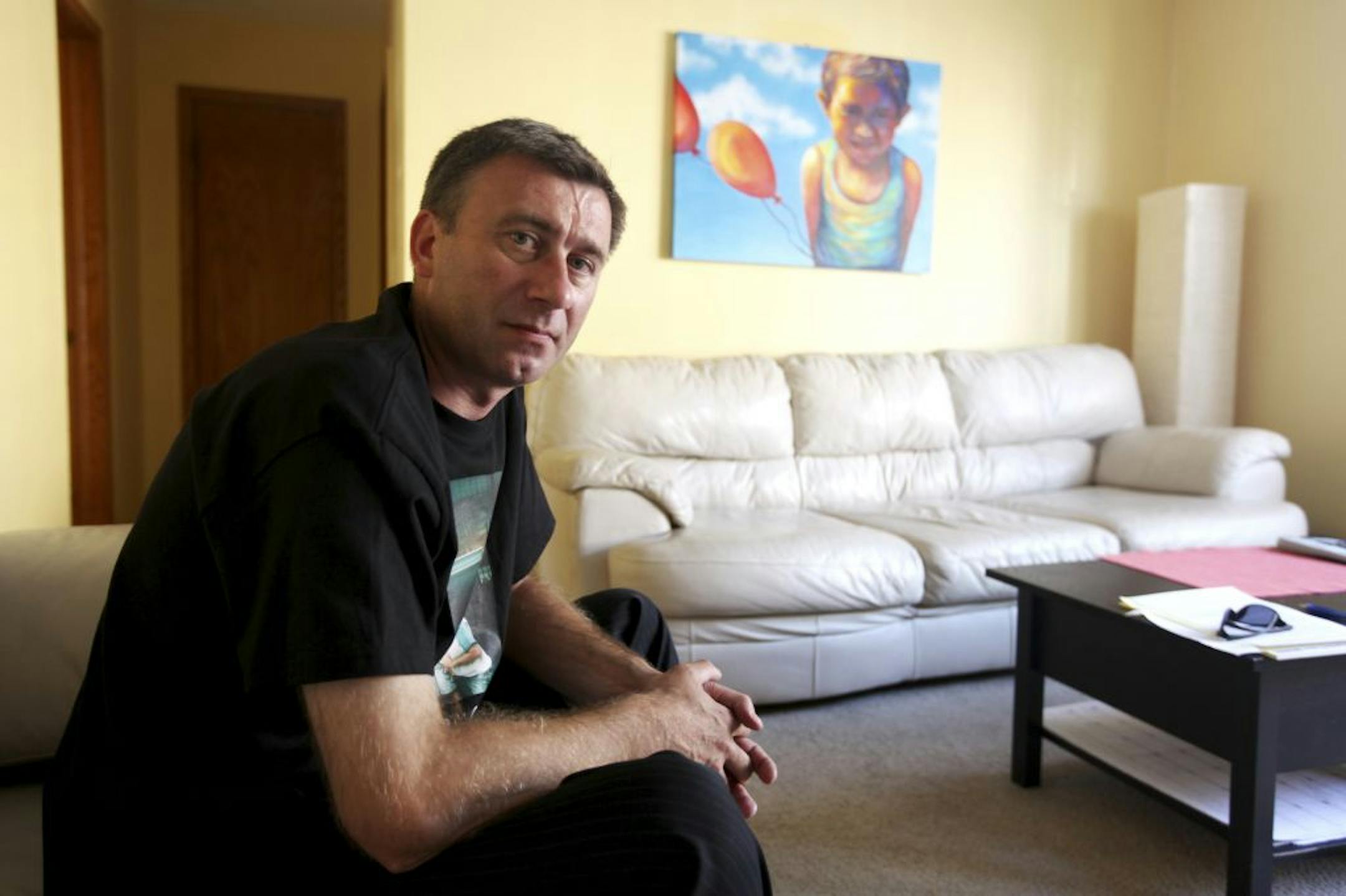 Tony Wasilewski with a portrait of his son, Brian, near Chicago. He sold the family home to help pay his wife and son's expenses in Poland.