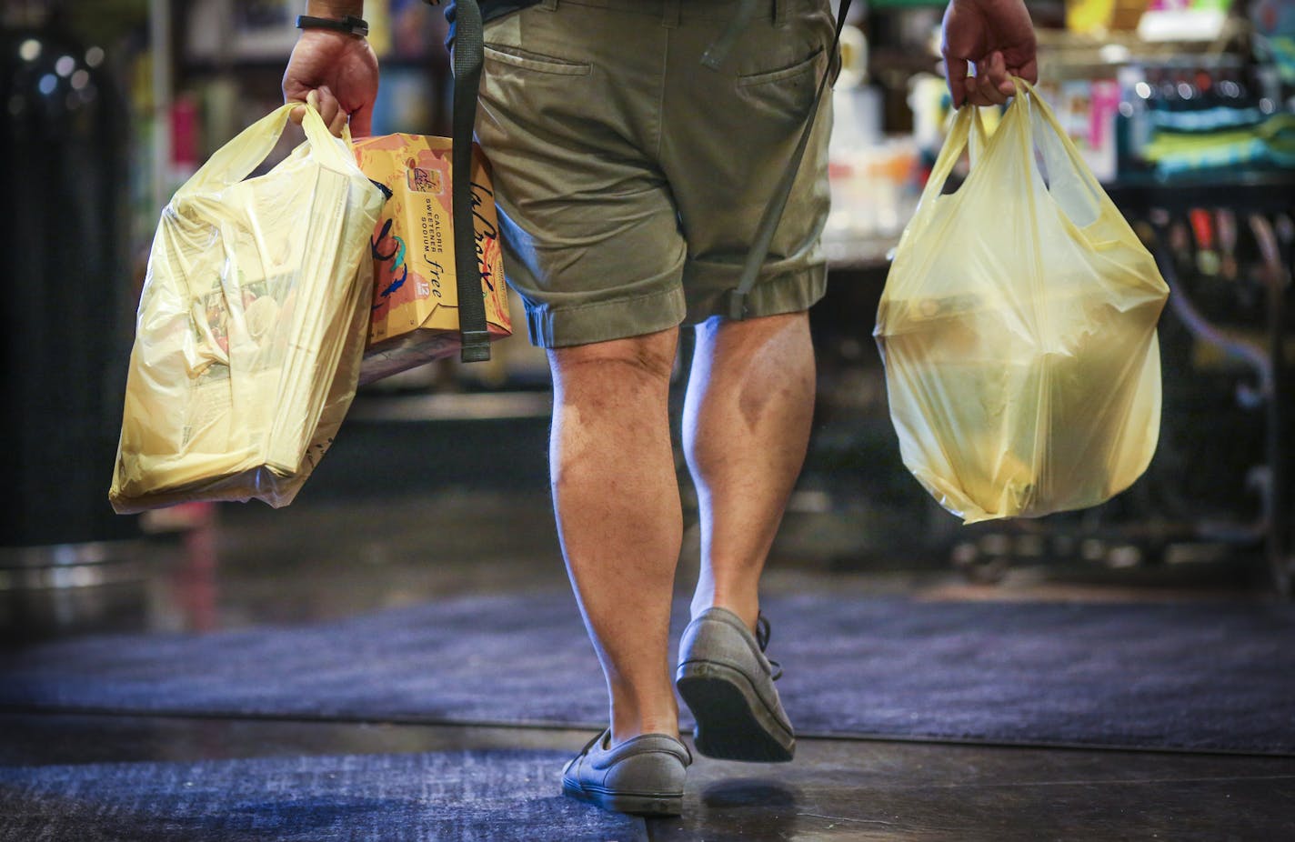 A man carried plastic bags of groceries out of Kowalski's in Uptown in Minneapolis, Minn., on Thursday, July 23, 2015. ] RENEE JONES SCHNEIDER &#x2022; reneejones@startribune.com