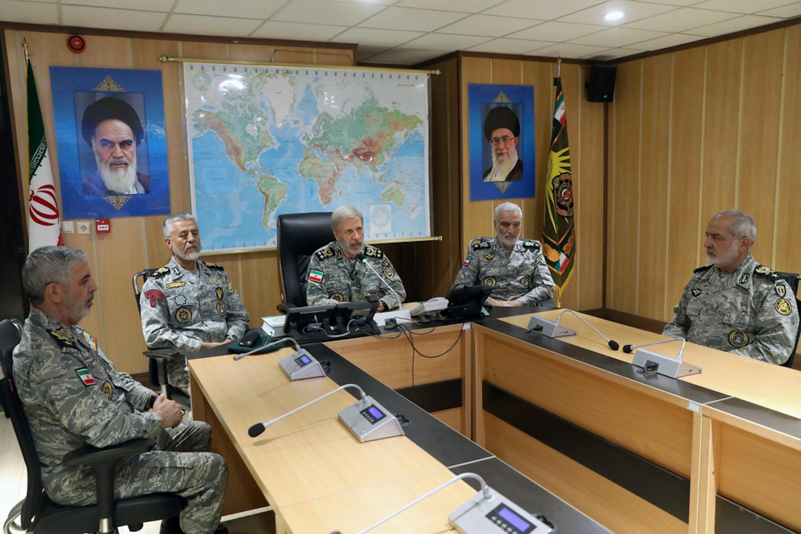 In this photo released on Monday, June 23, 2025, by Iranian army press service, Iran's army commander-in-chief Gen. Amir Hatami, center, accompanied by high ranked army commanders, speaks in a video call with top commanders of the army, in Zolfaghar central headquarters, Iran, as portraits of the late revolutionary founder Ayatollah Khomeini, left, and Supreme Leader Ayatollah Ali Khamenei hang on the wall. (Iranian Army Press Service via AP)