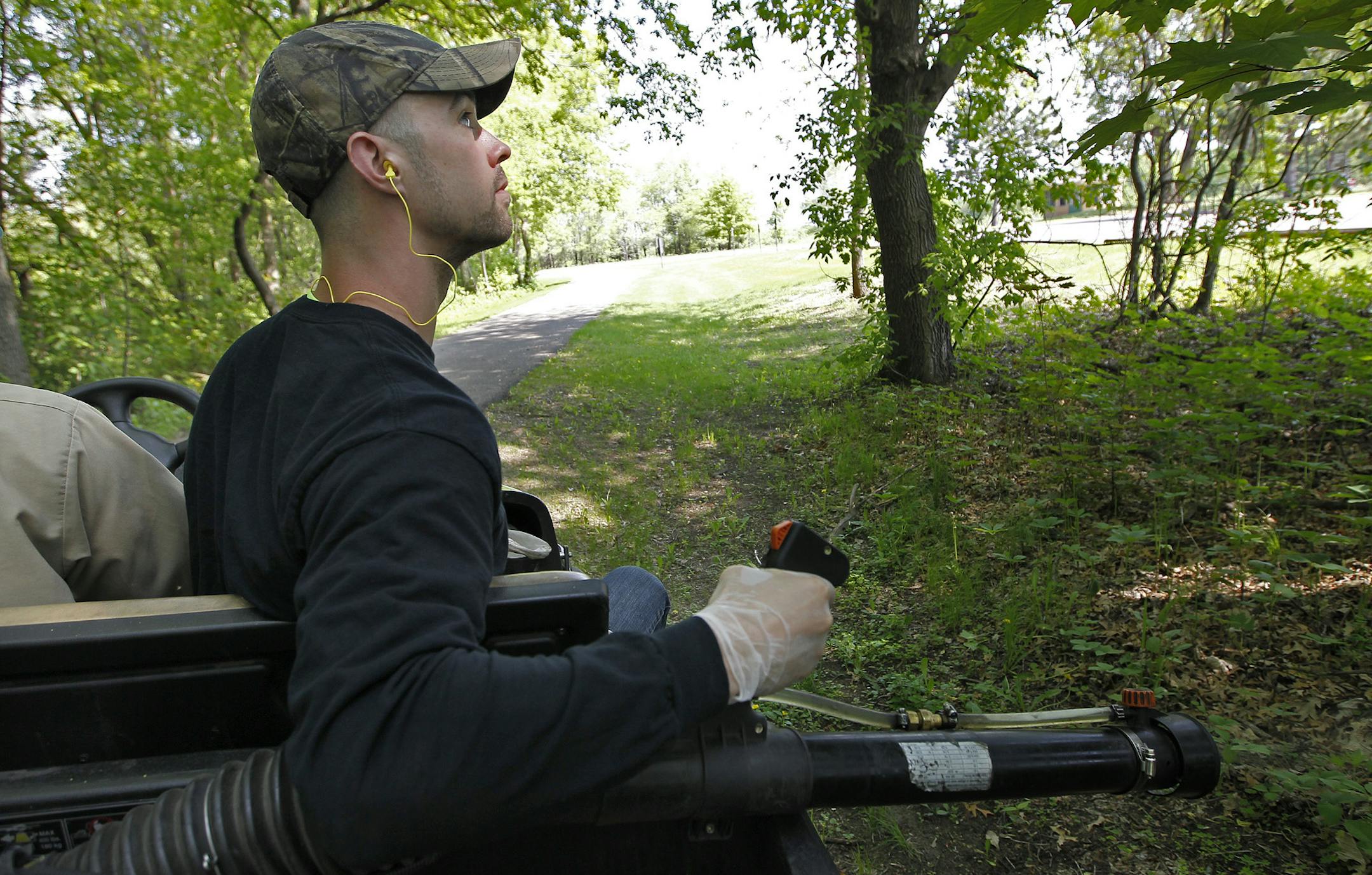 Metropolitan Mosquito Control experts, Mitch Orr, right, and Matt Vogel sprayed Permethrin in the wooded areas along Lake George to help diminish mosquitos, Friday, May 30, 2014 in Oak Grove, MN. ] (ELIZABETH FLORES/STAR TRIBUNE) ELIZABETH FLORES • eflores@startribune.com