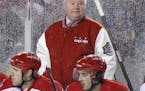 Washington Capitals head coach Bruce Boudreau stands behind players during the third period of the NHL Winter Classic outdoor hockey game against the 