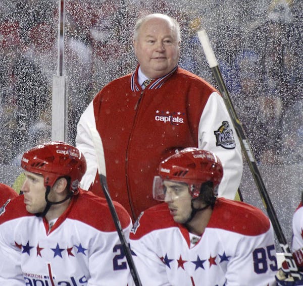 Washington Capitals head coach Bruce Boudreau stands behind players during the third period of the NHL Winter Classic outdoor hockey game against the 
