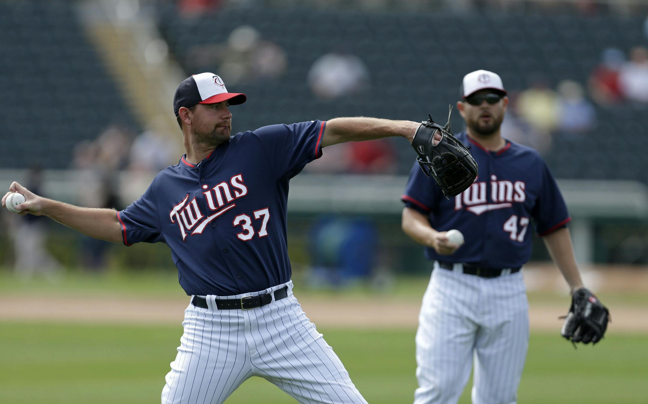 Minnesota Twins starting pitcher Mike Pelfrey (37) and starting pitcher Ricky Nolasco (47) warm up before an exhibition baseball game against the Boston Red Sox in Fort Myers, Fla., Friday, March 28, 2014. (AP Photo/Gerald Herbert)