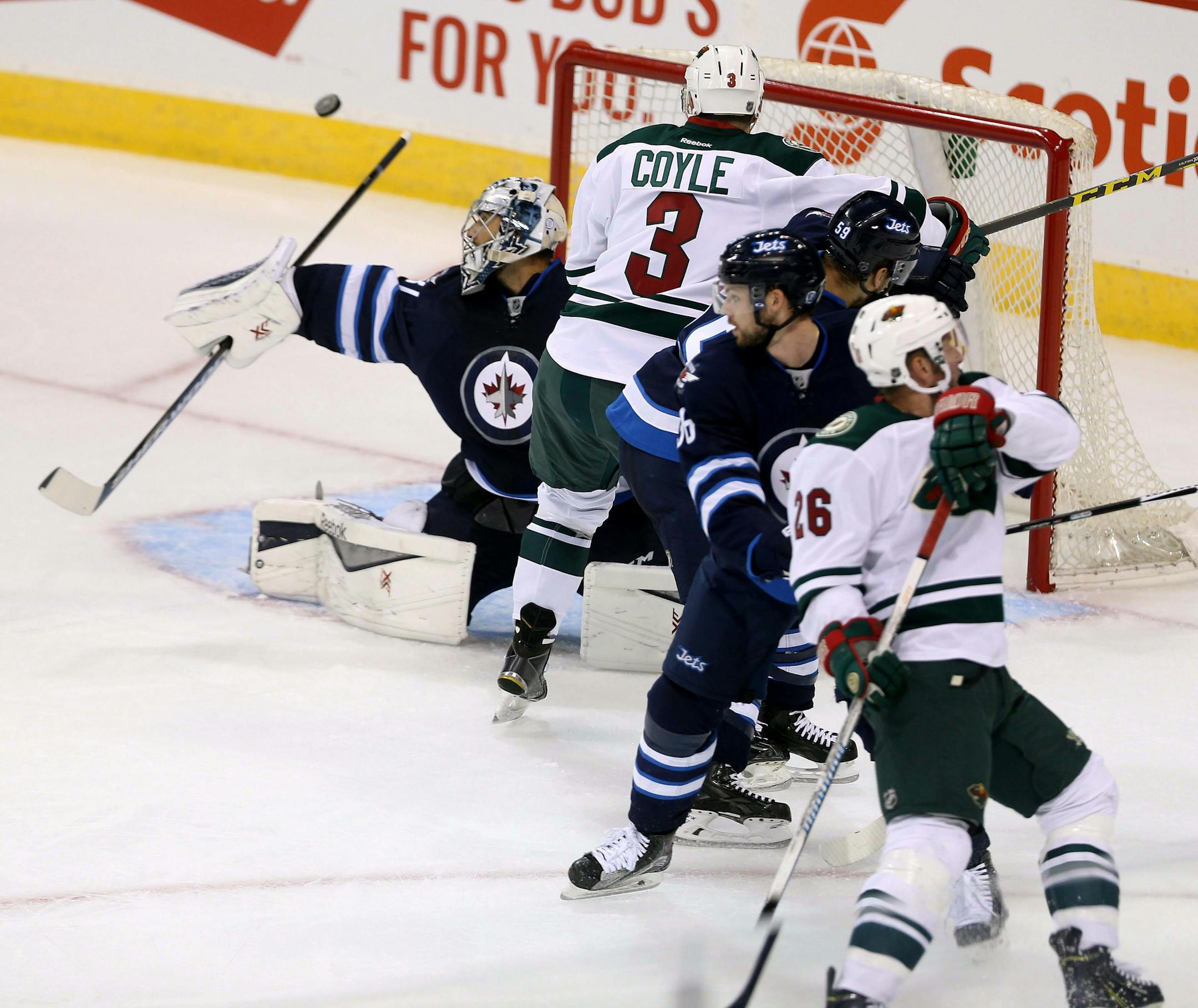 Winnipeg Jets' goaltender Ondrej Pavelec, left, makes a save against the Minnesota Wild during first period of an NHL preseason hockey game Tuesday, Sept. 22, 2015, in Winnipeg, Manitoba. (Trevor Hagan/The Canadian Press via AP) MANDATORY CREDIT