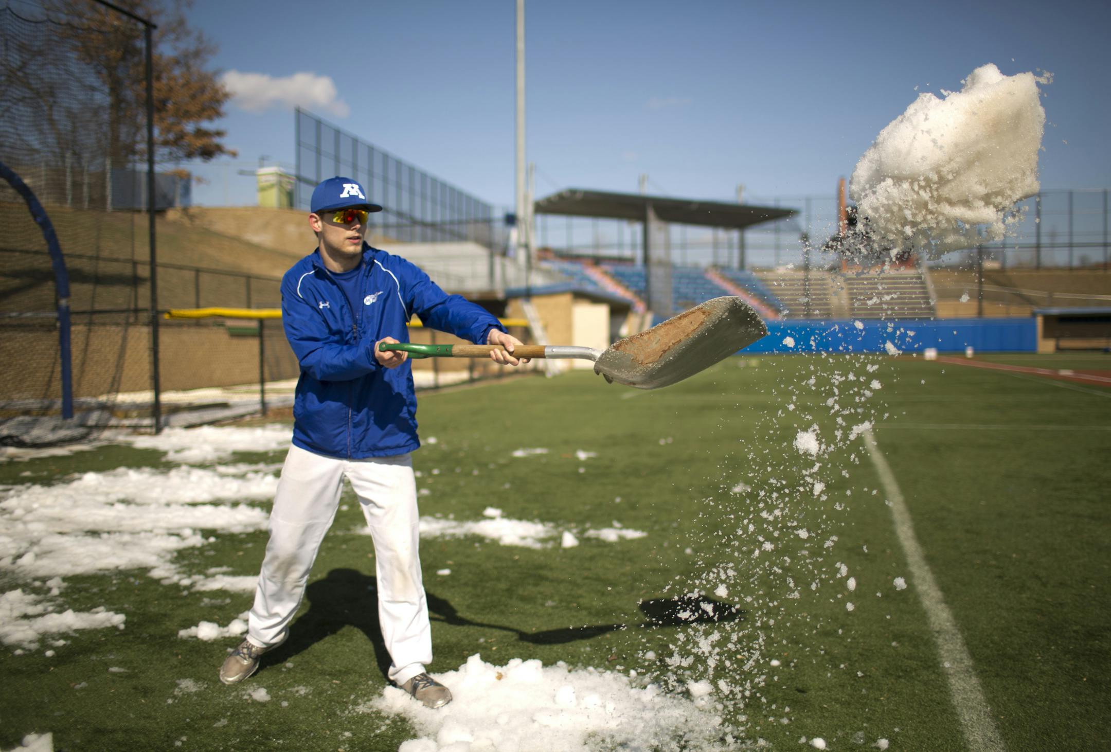 The late spring has set back high school baseball and softball programs big time. Minnetonka High School, fortunately, has a field turf on their baseball field, allowing them to work out on a dry field. Bjorn Hansen tossed snow onto the artificial turf to melt while he and a couple of other players dug out the batting cage from its winter parking spot at the edge of the field on a sunny and springlike Tuesday afternoon, April 2, 2013. ] JEFF WHEELER ‚Ä¢ jeff.wheeler@startribune.