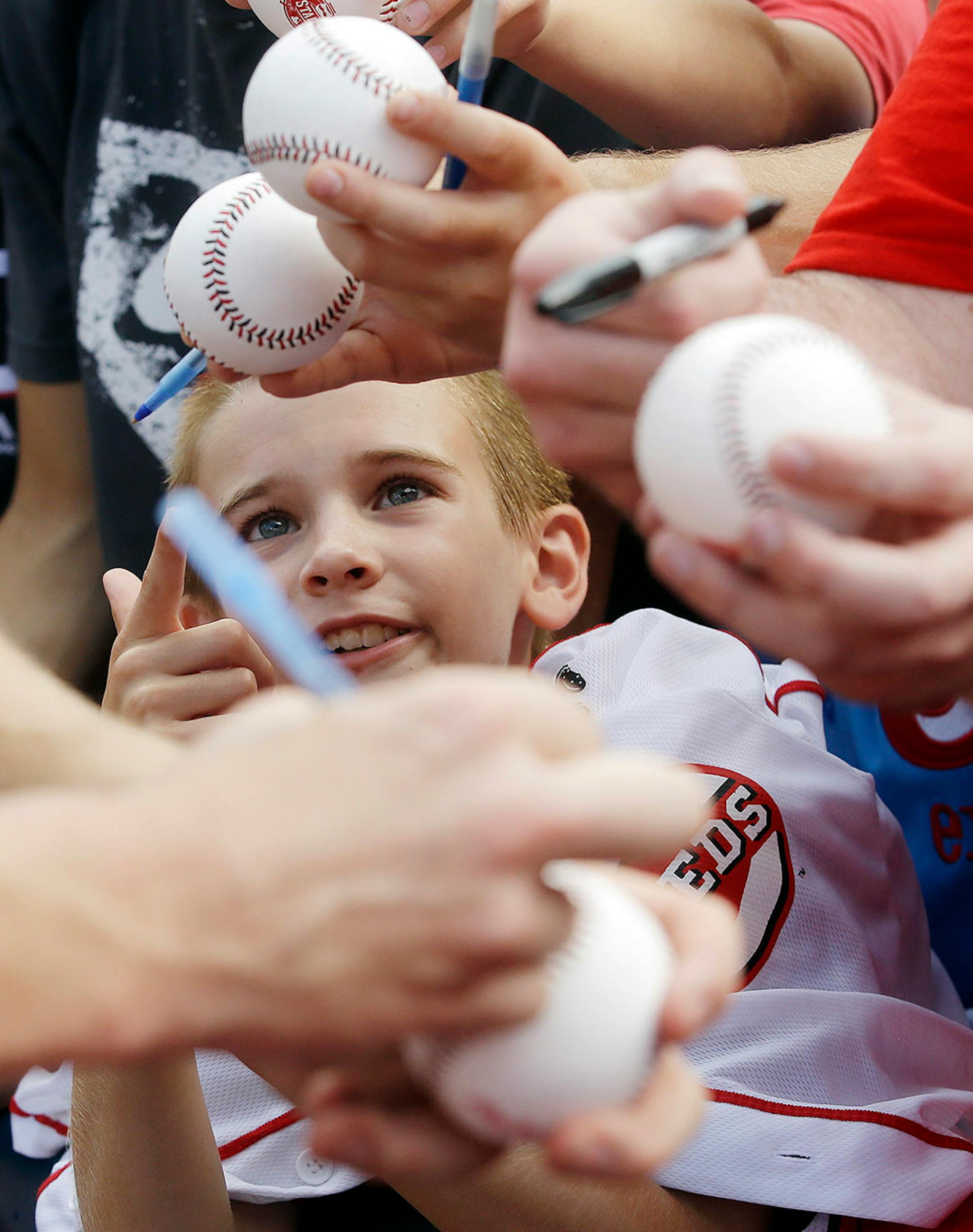 A fan watches as National League's Mark Melancon, of the Pittsburgh Pirates, signs autographs for fans before the MLB All-Star baseball game, Tuesday, July 14, 2015, in Cincinnati.