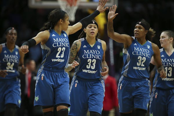 Minnesota Lynx forward Maya Moore (23) and forward Rebekkah Brunson (32) high fived over guard Seimone Augustus (33) as they headed to the bench for a