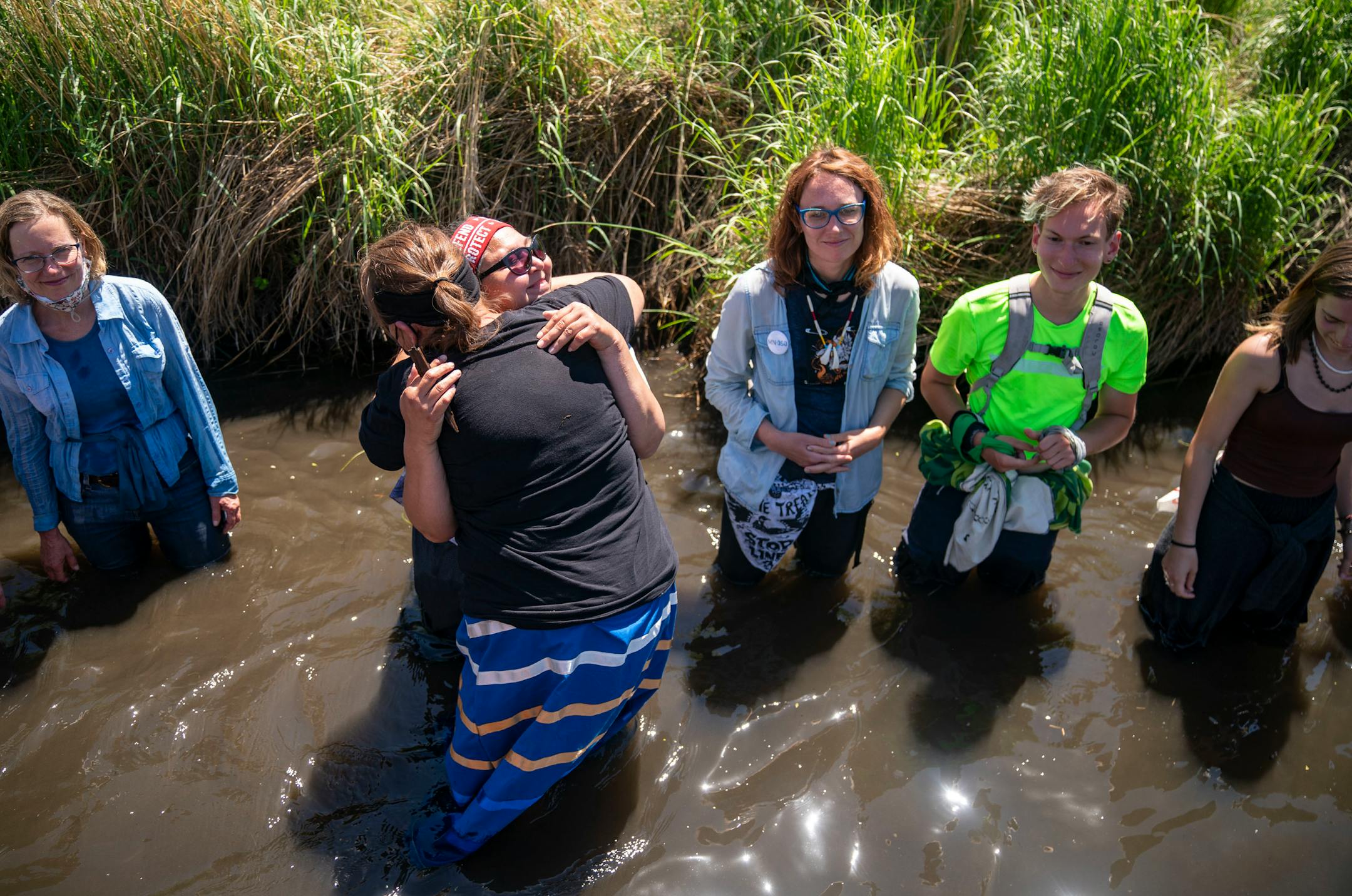 Nancy Beaulieu embraced Everlasting Wind aka Dawn Goodwin during after performing tribal dances in the Mississippi River near an Enbridge pipeline construction site on Monday. The two women are self-described "tribal sisters" and co-founders of RISE Coalition.