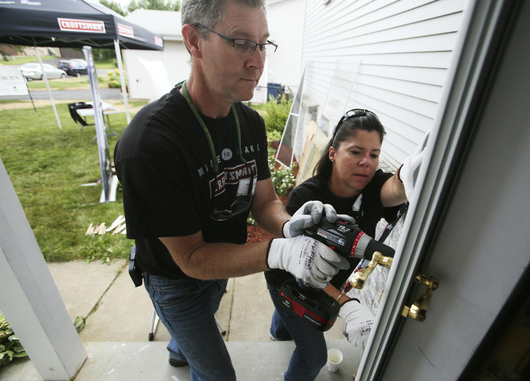 Project volunteers Patrick Johnson, left, and Brenda Tresco, right, who work for Greiner Construction of Minneapolis, work on installing a front storm door for the Peterson home in Rosemount, MN, Friday, July 26, 2013.](DAVID JOLES/STARTRIBUNE) djoles@startribune.com Joy Peterson, the mother of National Guard soldier Dominic Peterson, is having her home remodeled/rebuilt. Volunteers will make improvements to the home as part of a national tour to help veterans and their families. The efforts are