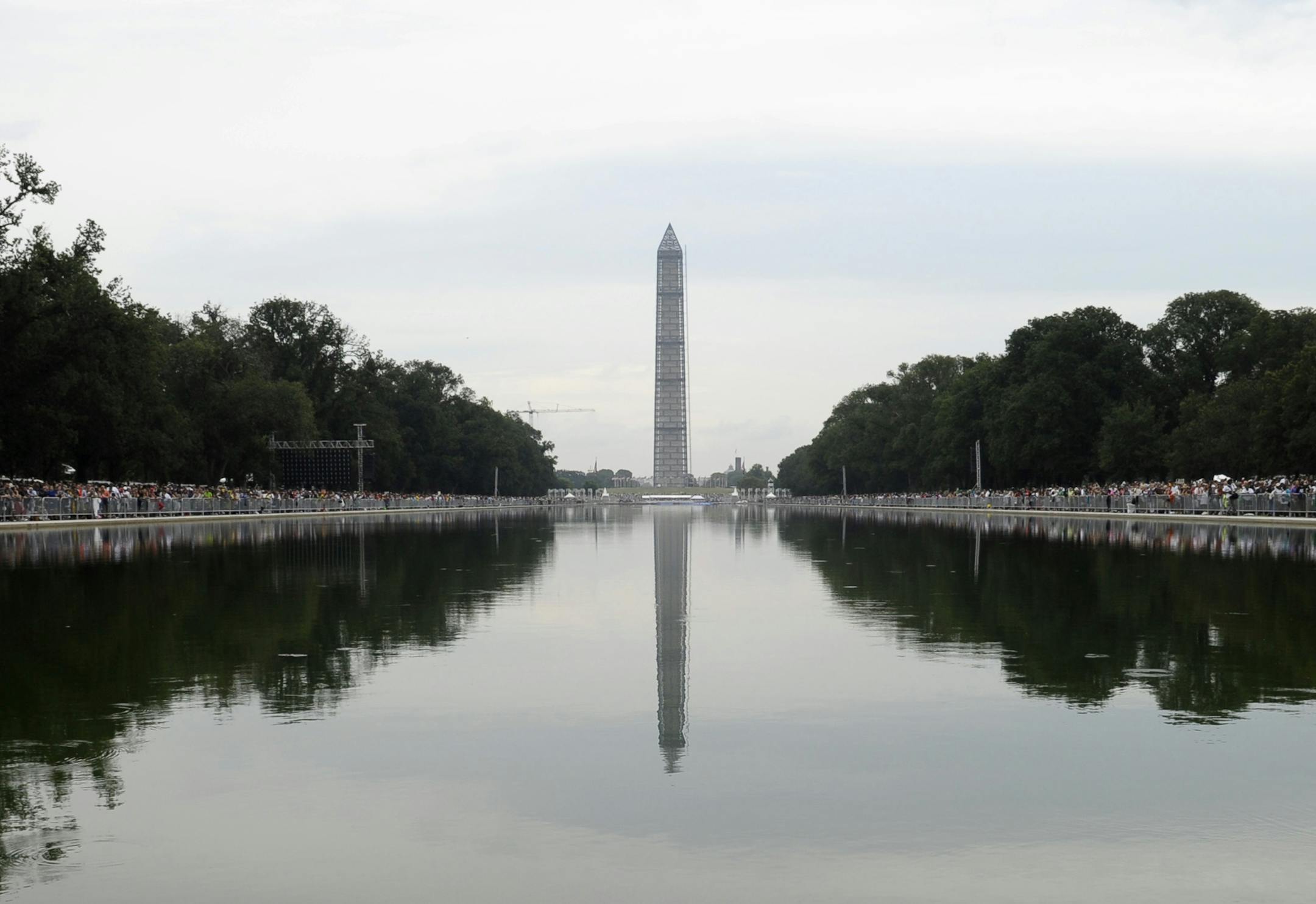People gather around the reflecting pool, looking toward the Washington, Monument, near the Lincoln Memorial in Washington, Wednesday, Aug. 28, 2013, to listen to President Barack Obama speak during the 50th anniversary of the March on Washington. President Barack Obama led civil rights pioneers Wednesday in a ceremony for the 50th anniversary of the March on Washington, where Dr. Martin Luther King's "I Have a Dream" speech roused the 250,000 people who rallied there decades ago for racial equa