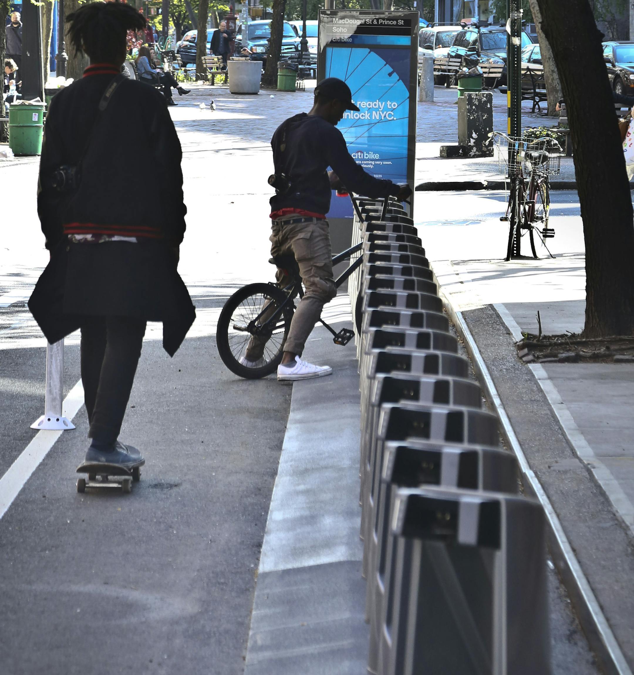 In this May 1, 2013 photo, a bicyclist pulls into a docking rack at a site for a new bike share program, on MacDougal Street in New York. This month, New York will join the ranks of Paris, London, Madrid and Washington by enacting its first-ever bike share program. (AP Photo/Bebeto Matthews) ORG XMIT: MIN2013051709410213