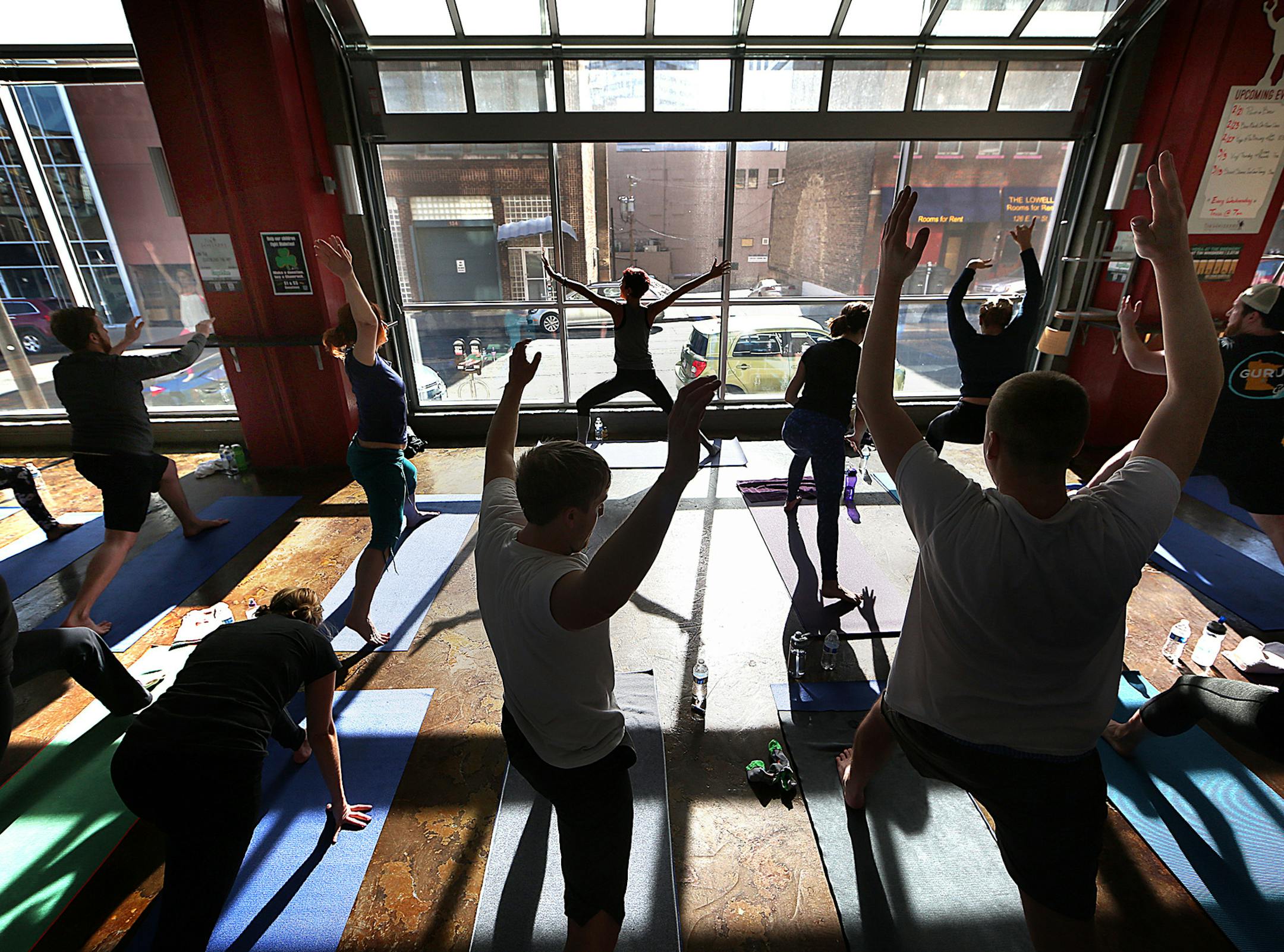 Instructor Elle Anna Lemler, top center, leads a yoga class at the Tin Whiskers Brewing Company in St. Paul, Minn., on February 27, 2016. Recent studies found that the more people work out, the more they drink. (Jim Gehrz/Minneapolis Star Tribune/TNS) ORG XMIT: 1181503