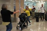 Cheri Phillips greets her mother, Lori Tocholke, as she arrives home to Minnesota with her husband Chris, right, and son Greyson at Minneapolis-St. Pa