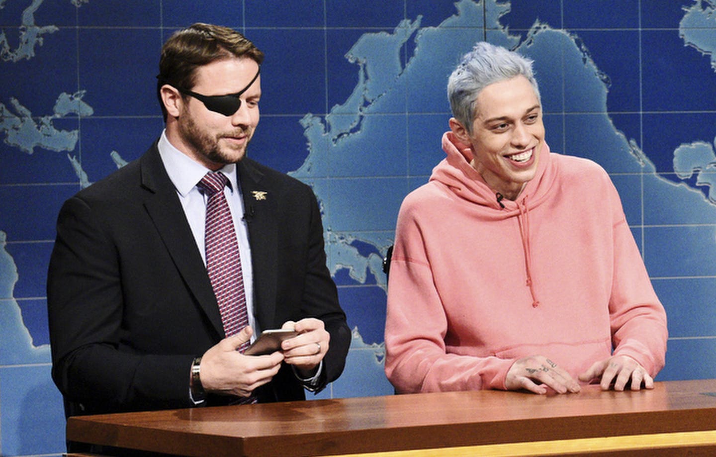 In this Nov. 10, 2018 photo provided by NBC, Lt. Com. Dan Crenshaw, from left, a congressman-elect from Texas, Pete Davidson, Anchor Colin Jost, and Anchor Michael Che appear during Saturday Night Live&#xed;s "Weekend Update" in New York. Davidson made his apologies to Crenshaw whose appearance he mocked, saying Crenshaw &#xec;deserves all the respect in the world.&#xee; (Will Heath/NBC via AP)