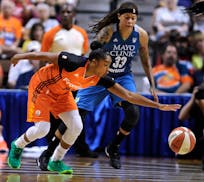 Connecticut Sun's Alex Bentley, left, reaches for a loose ball against Minnesota Lynx's Seimone Augustus, right, during the first half of a WNBA baske