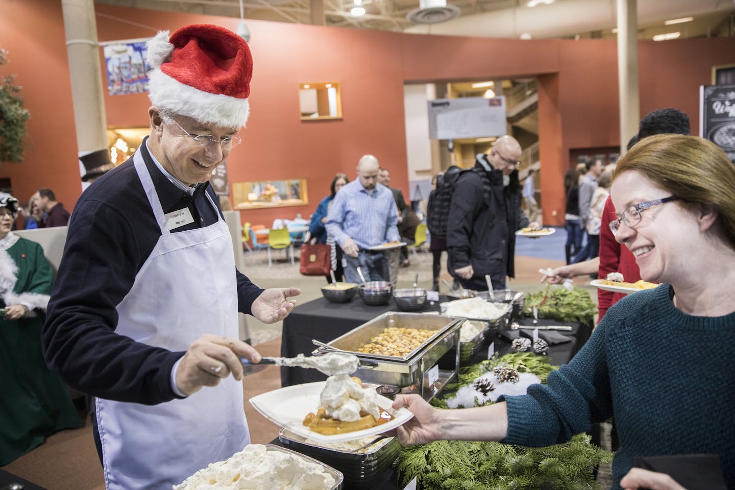 Best Buy CEO Hubert Joly serves waffle toppings on Monday to employee Jackie Schlitz, who works in disaster recovery at Best Buy. ] LEILA NAVIDI &#xef; leila.navidi@startribune.com