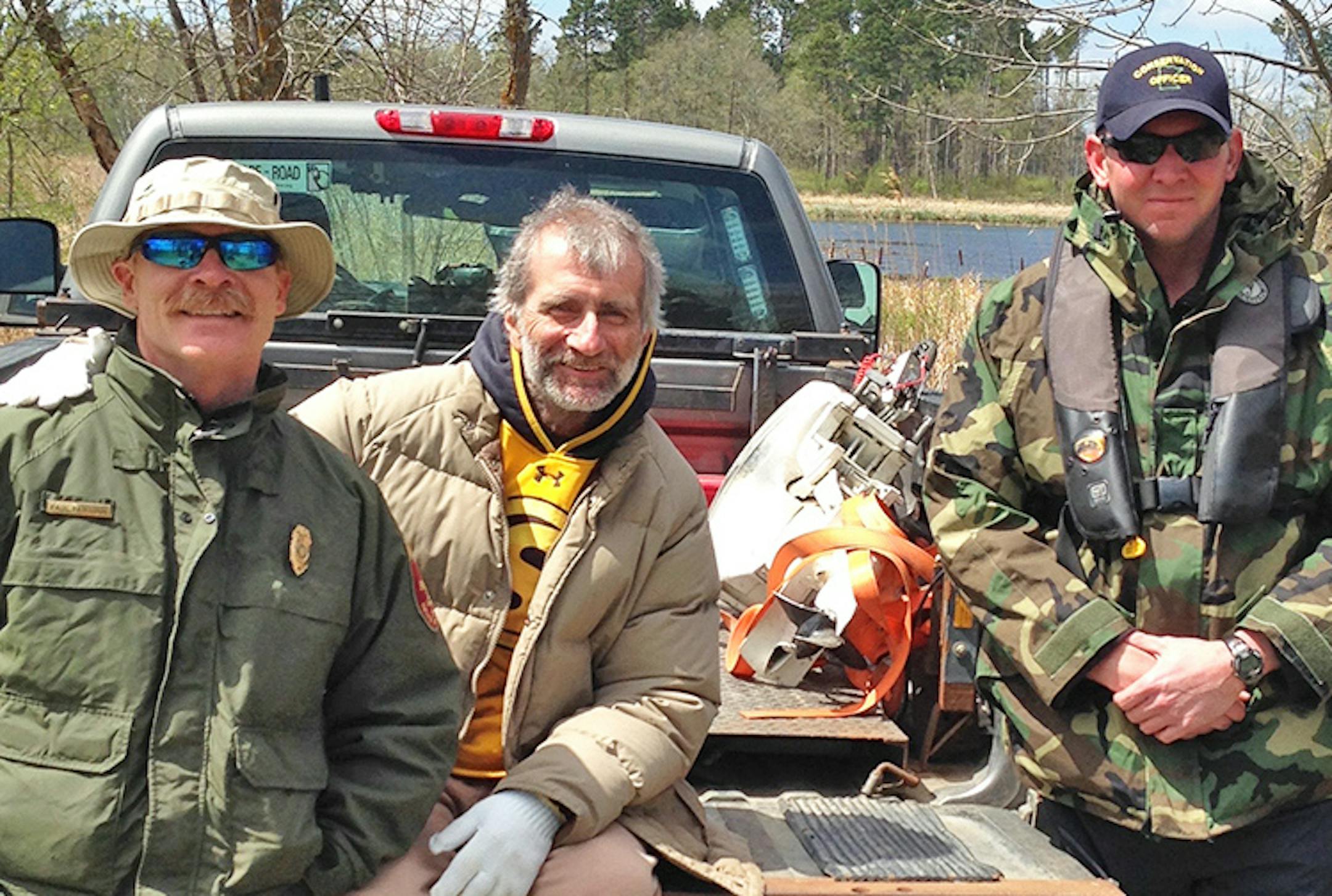 Utah kayaker Michael Stone, center, became stranded on a mud flat in the Mississippi headwaters last week, just as a cold front was intensifying with snow, sleet and high winds. As hypothermia and frostbite were seting in, he became paralyzed from the cold and was rescued by two DNR conservation officers, Paul Parthun, left, and Brian Holt, right.  The officers had to paddle and pole in a canoe to reach Stone, and he was too incapacitated to help them paddle out.  The three are picture