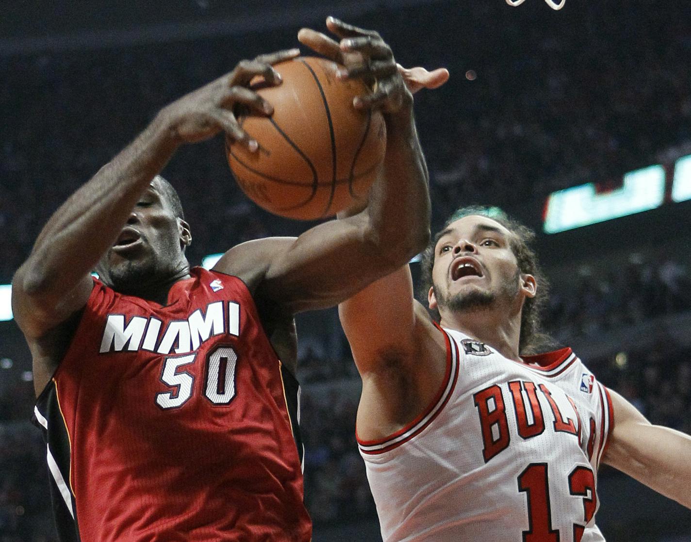 Miami Heat center Joel Anthony, left, and Chicago Bulls center Joakim Noah reach for a rebound during the first quarter of Game 5 of the NBA basketball Eastern Conference finals Thursday, May 26, 2011, in Chicago. (AP Photo/Charles Rex Arbogast)