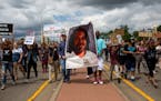 Protesters hold an image of Philando Castile and march down the street during a protest on Sunday, June 18, 2017 in St. Anthony, Minn. (Courtney Pedro