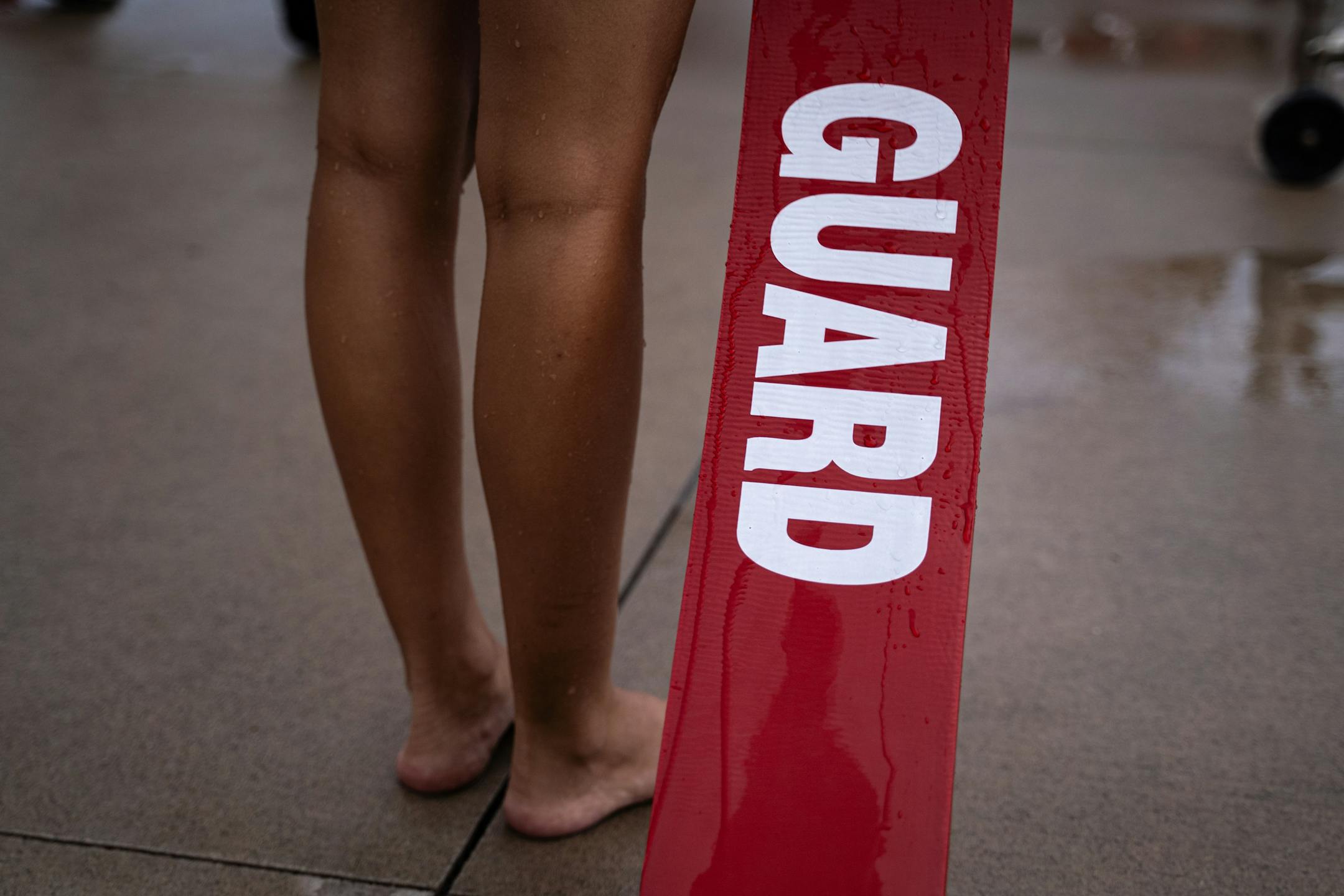 A lifeguard in training holds a rescue tube during lessons.
